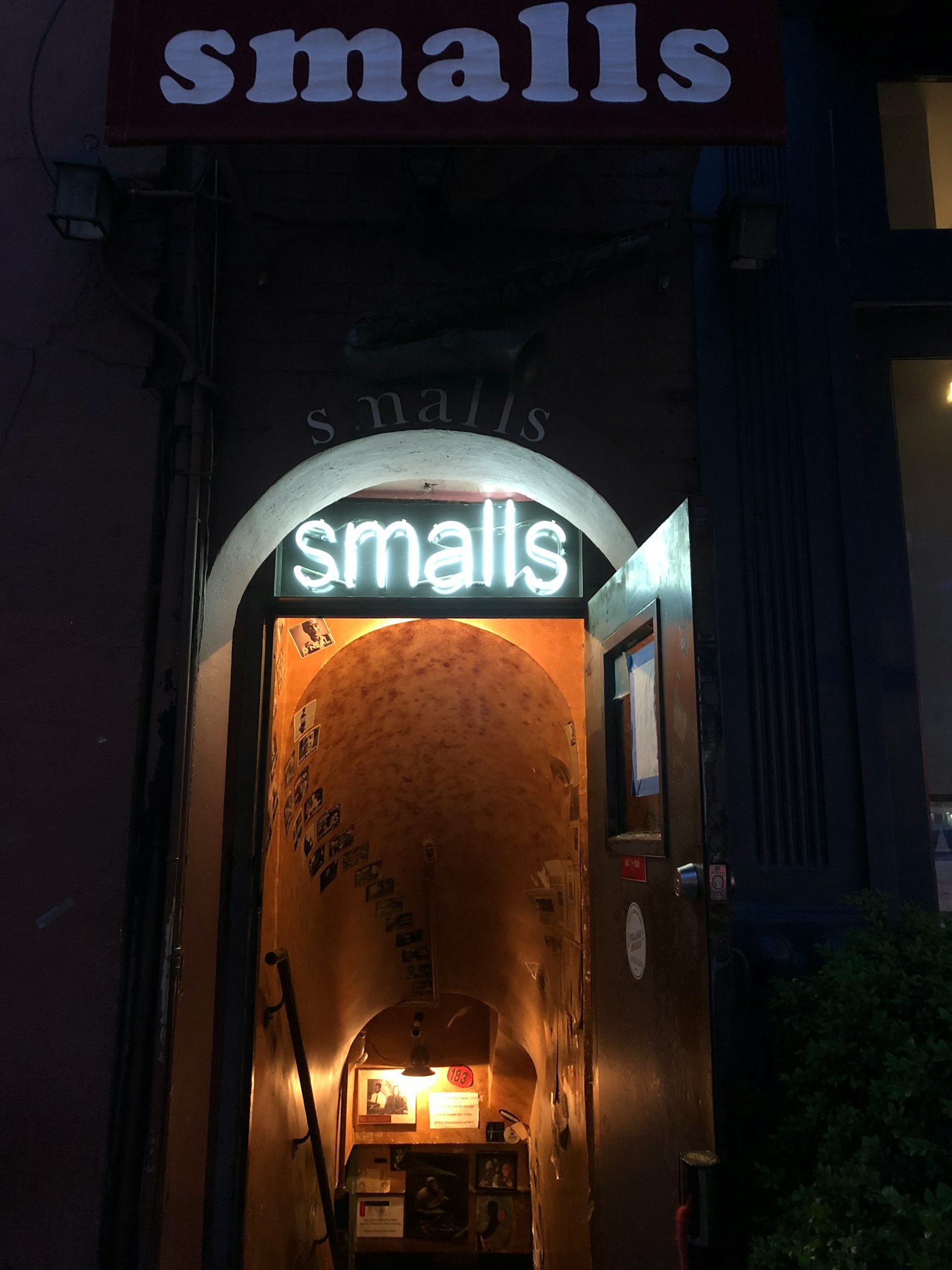 昏暗入口處發光的'smalls'招牌