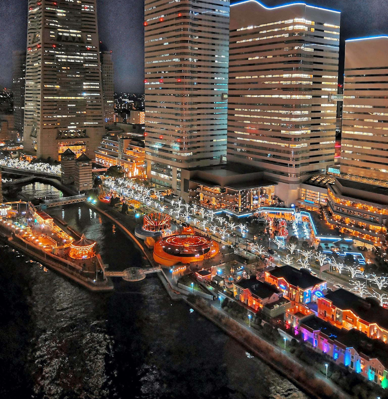 Paesaggio urbano notturno con edifici scintillanti e decorazioni illuminate lungo il fiume