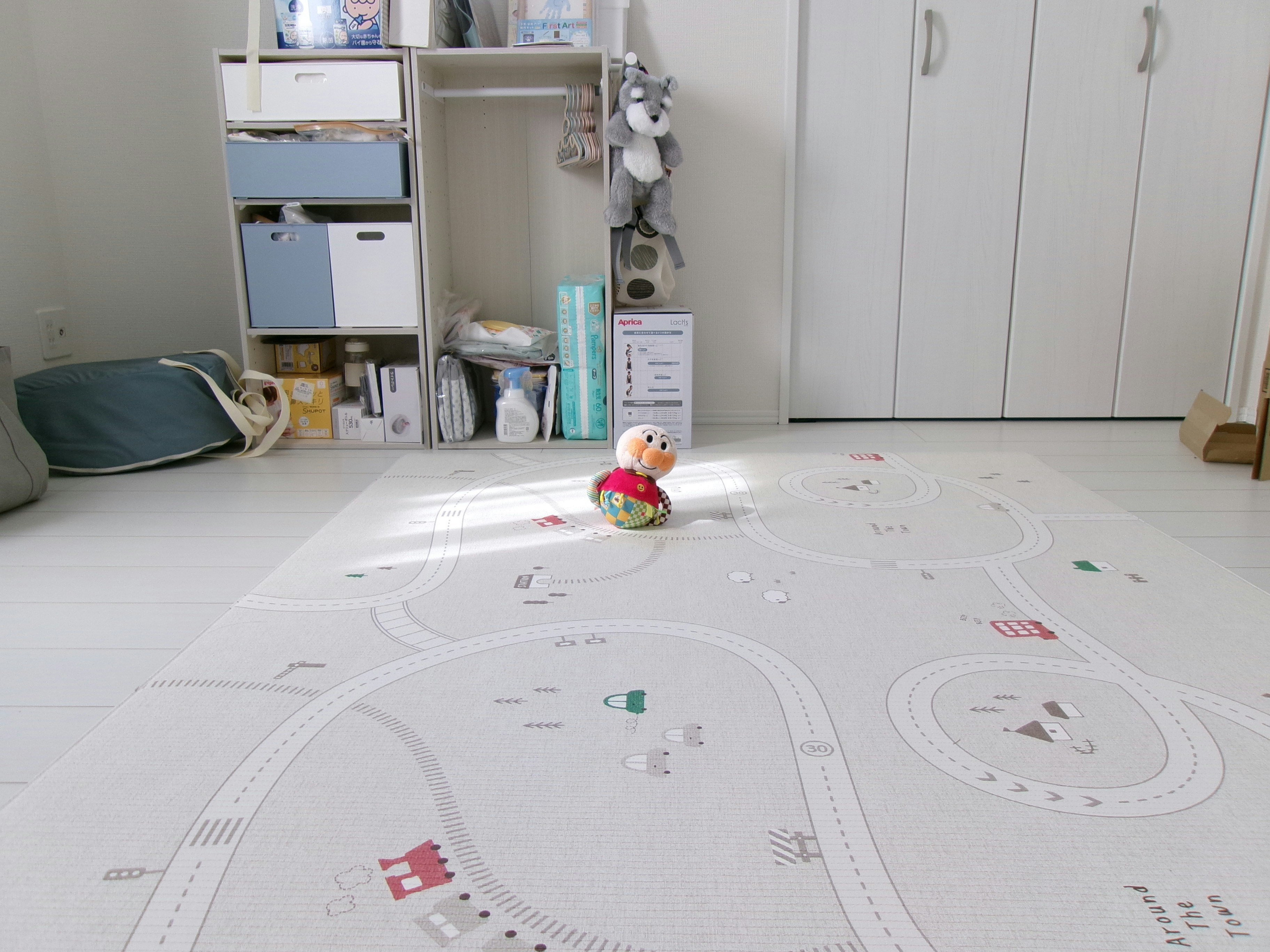 子ども用の遊びマットの上でおもちゃを見つめる室内の様子