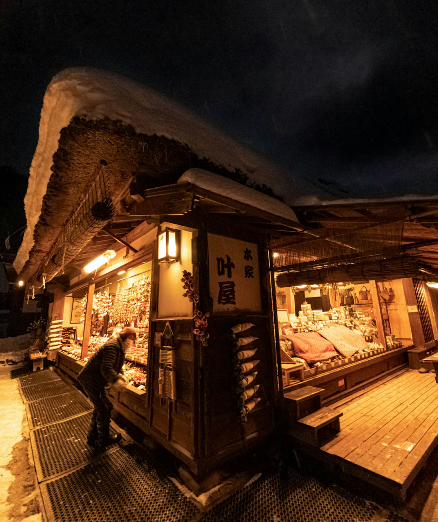Negozio giapponese tradizionale coperto di neve illuminato di notte