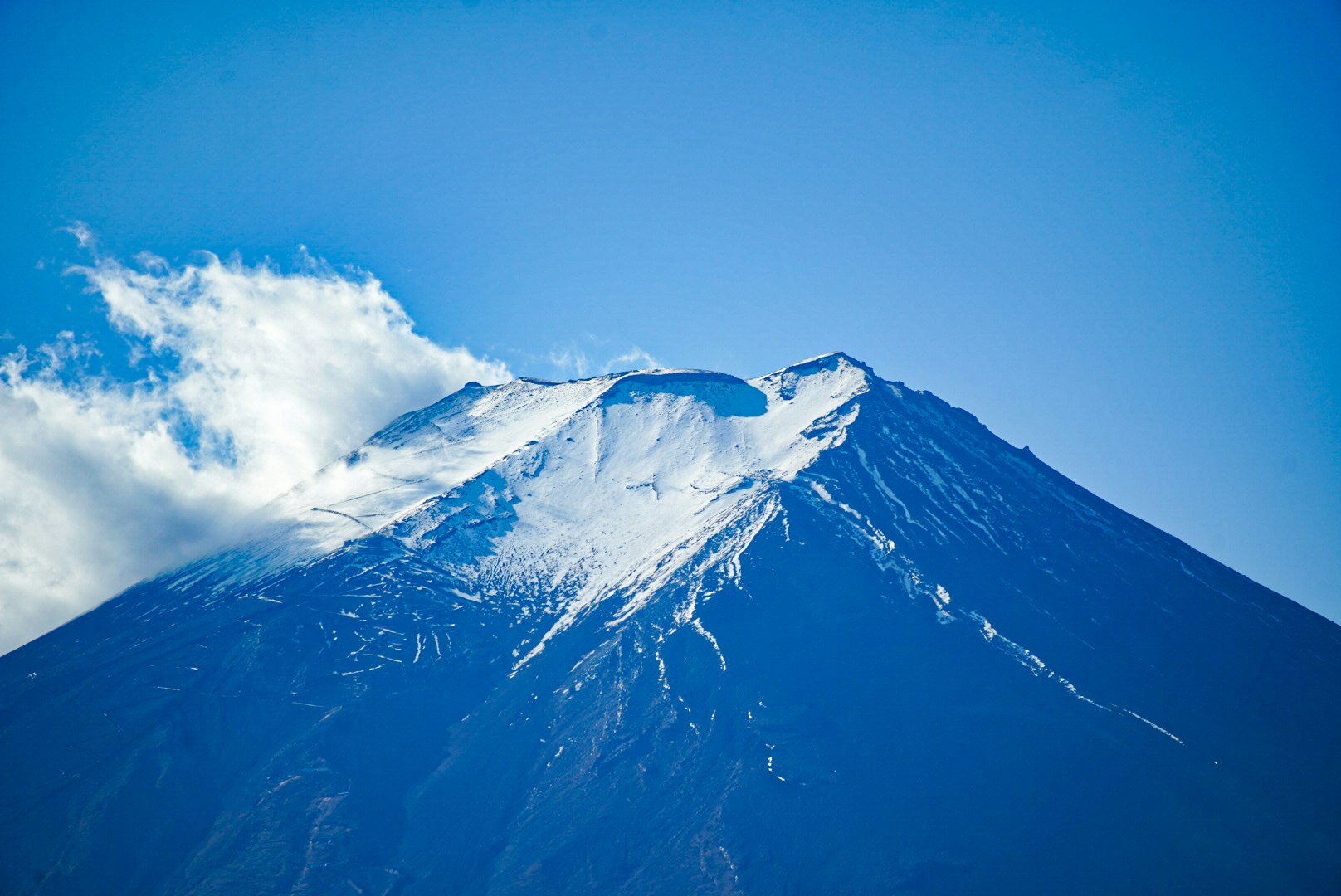 青空の下で雪をまとった山の雄大な稜線