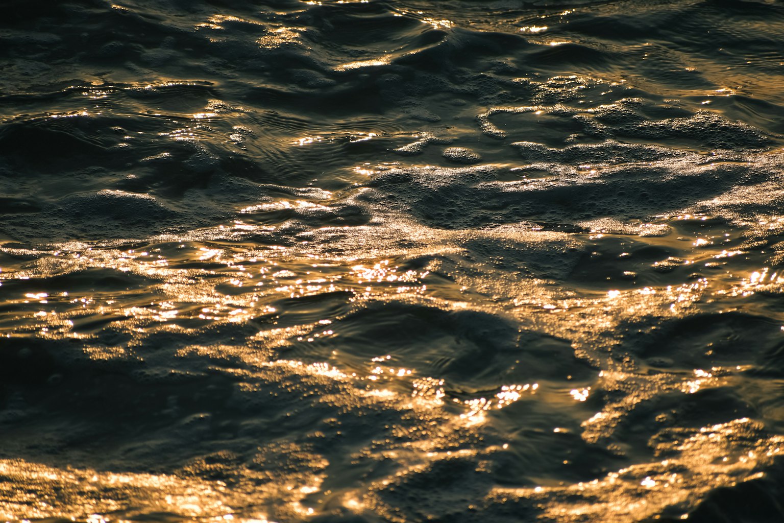 波の上に反射する金色の光が美しい海の水面