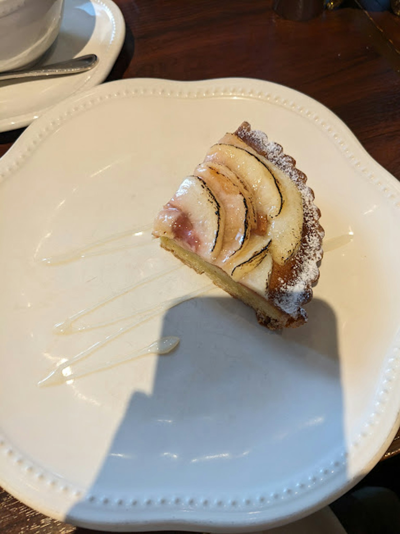 Ein Stück Kuchen mit Bananenscheiben auf einem weißen Teller