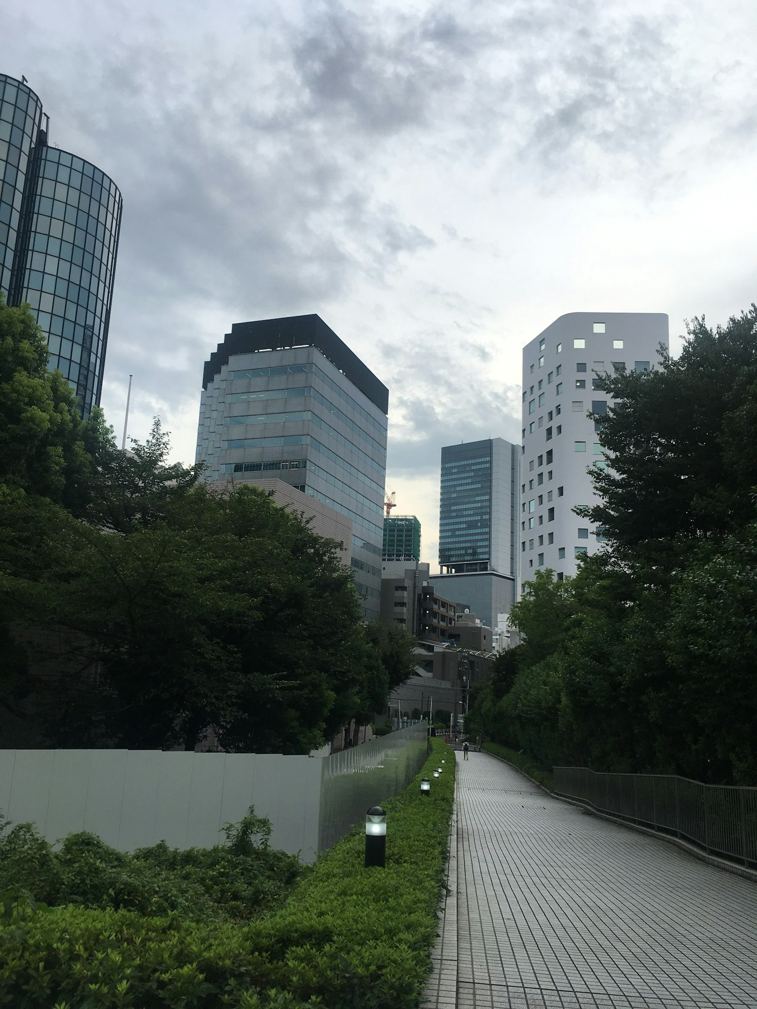ทิวทัศน์เมืองที่มีอาคารทันสมัยและทางเดินสีเขียว