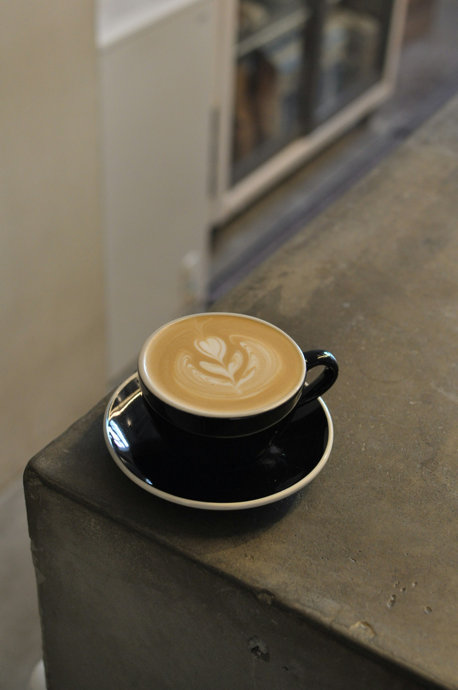 Latte Art Kaffee in einer schwarzen Tasse auf einem Tisch