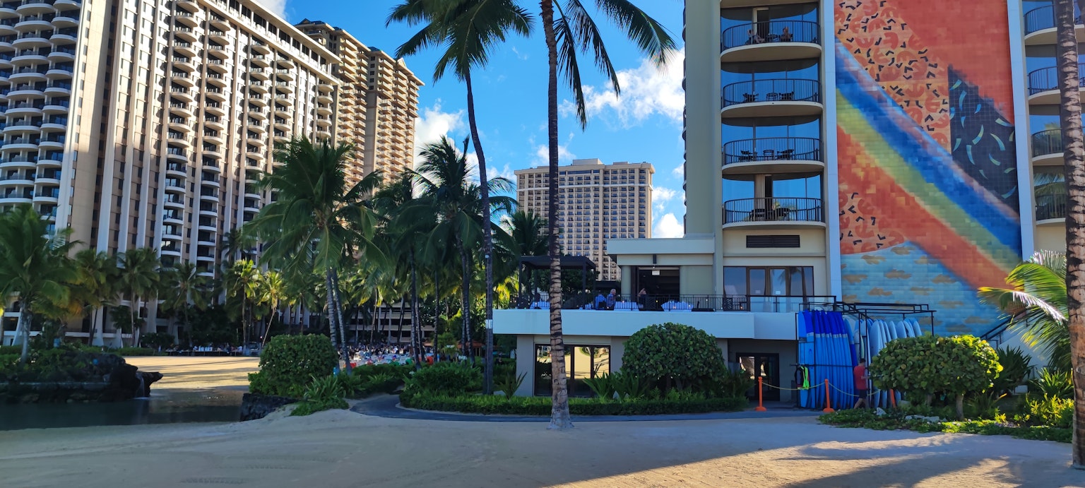Aussicht auf ein hawaiianisches Strandresort mit Hochhäusern und farbenfrohem Wandgemälde