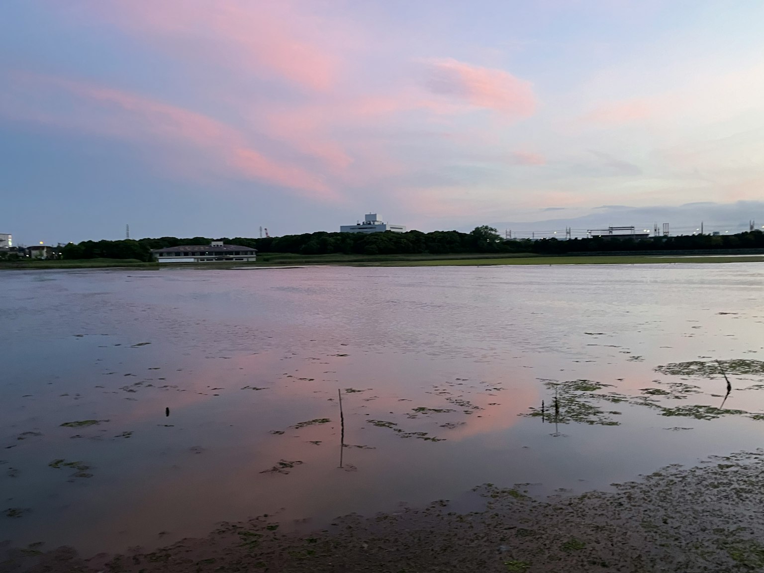 Calm water reflecting a colorful sunset sky and serene landscape