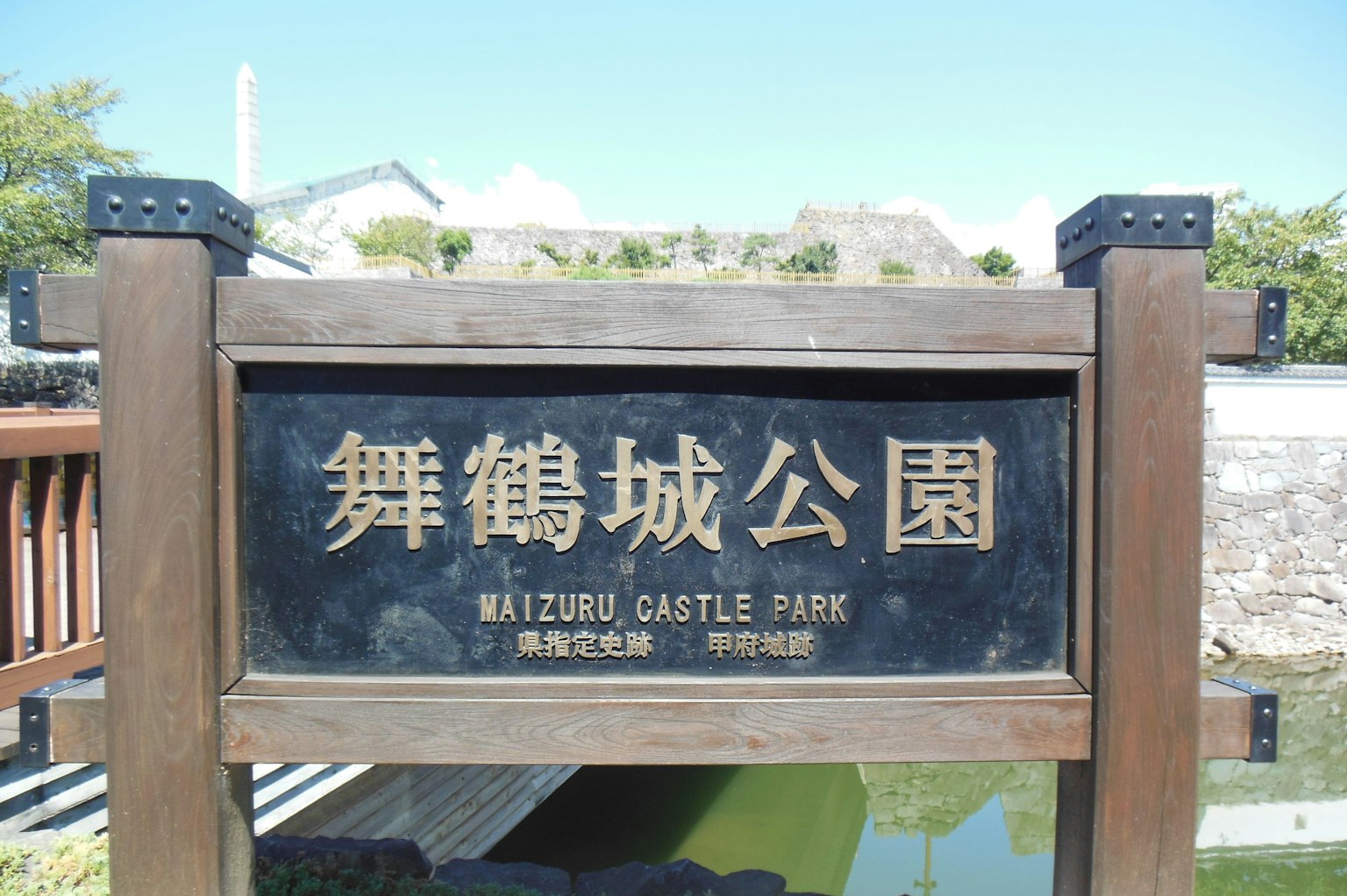 Insegna del parco del castello di Maizuru montata su pali di legno