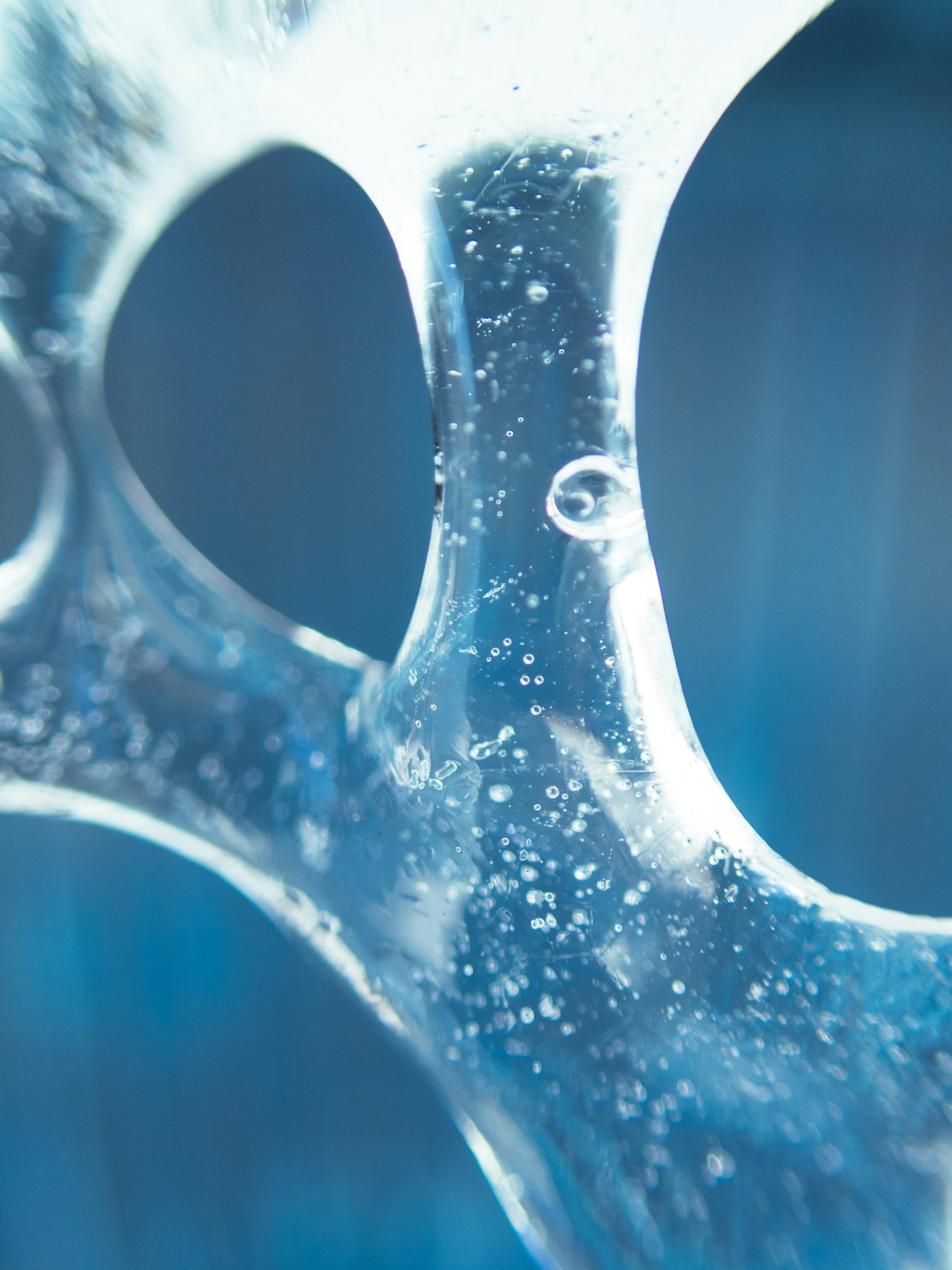 Primer plano de burbujas de líquido transparente con fondo azul