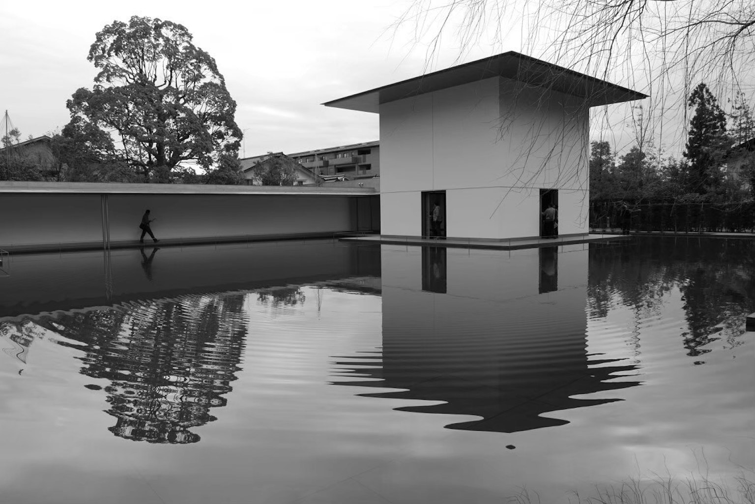 Un paesaggio sereno con un edificio bianco che si riflette sulla superficie dell'acqua