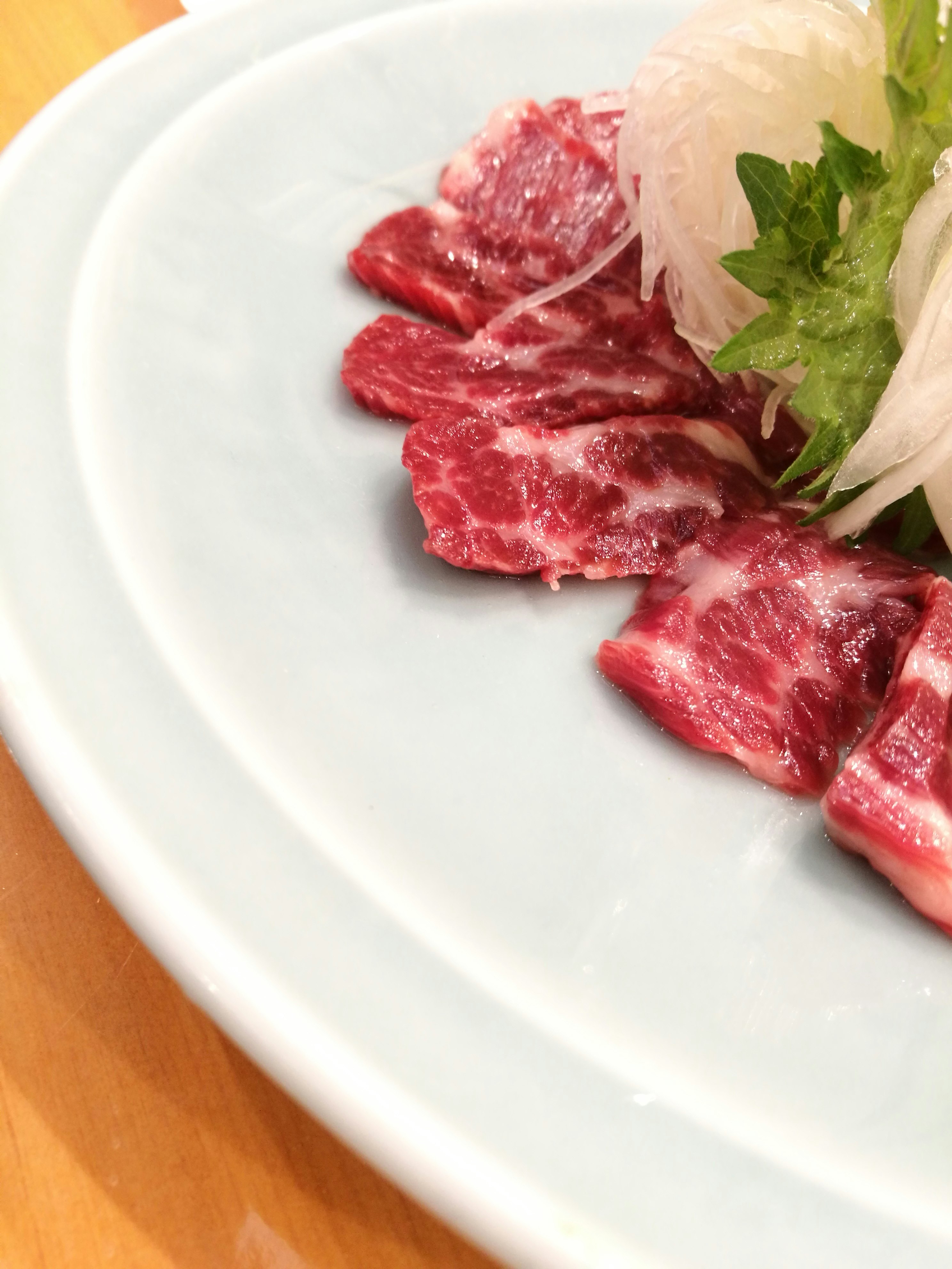 白い皿に盛られた生の牛肉のスライス