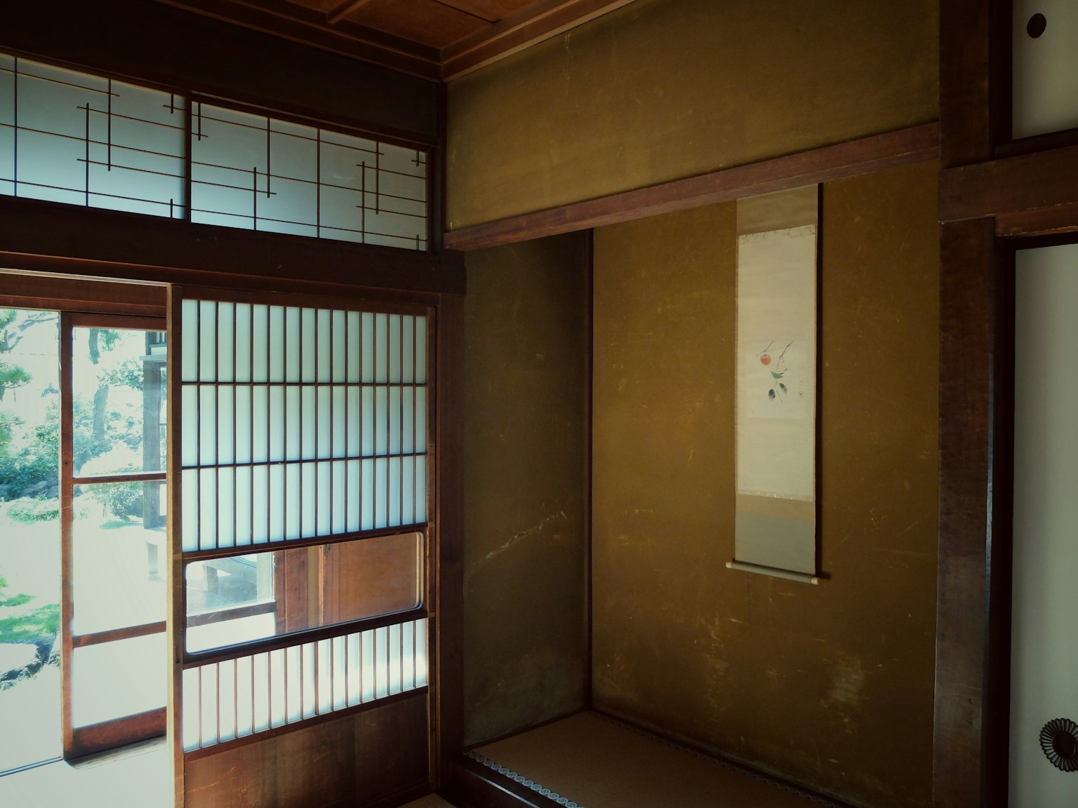 Traditional Japanese room interior with wooden walls and shoji screens featuring a tatami mat