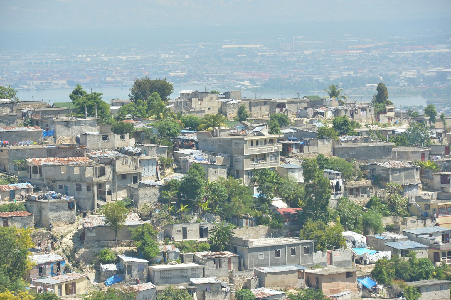 Vista de casas densamente pobladas en Haití rodeadas de vegetación desde una colina