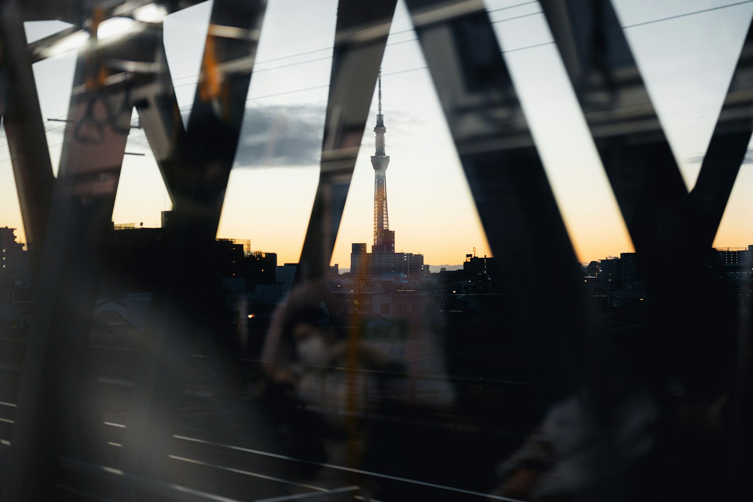 Tokyo Skytree en silueta contra el atardecer a través de una ventana