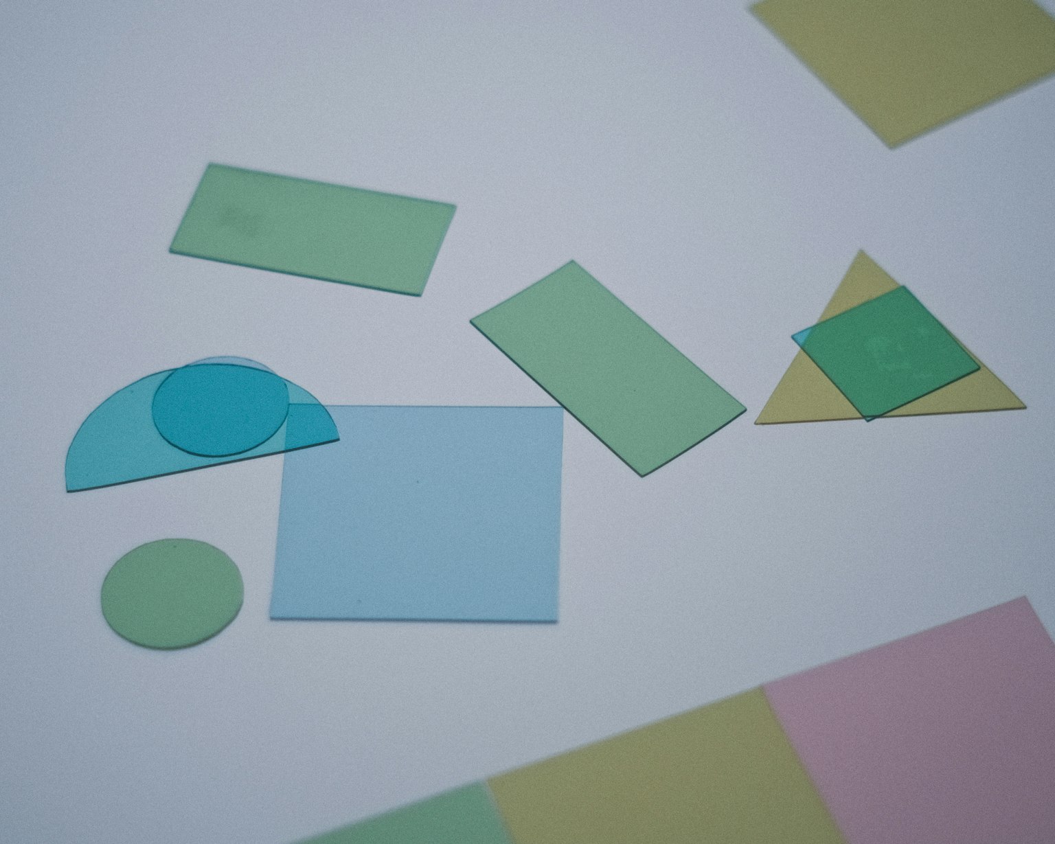 Formes en papier colorées disposées sur un fond blanc