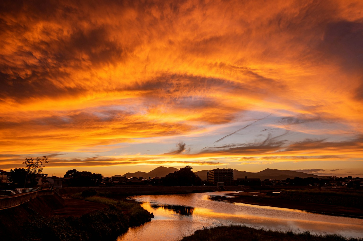 Stunning orange sunset sky over a calm river landscape