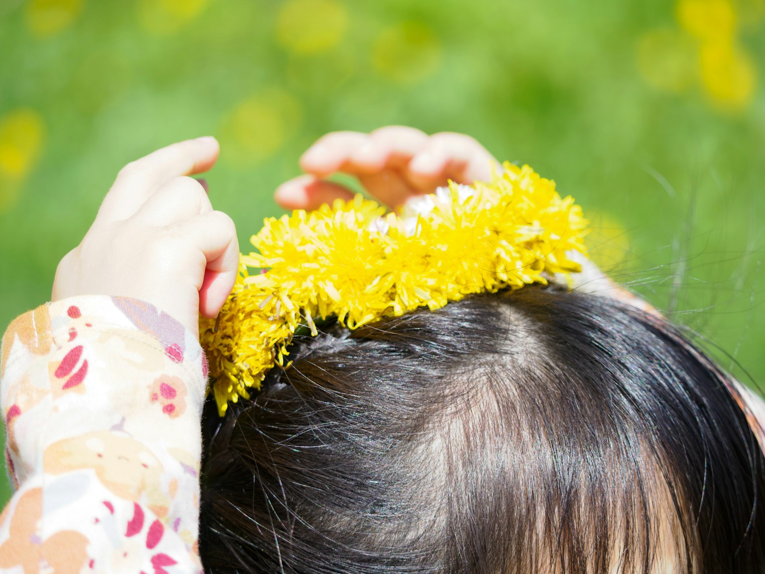 Bambino che crea una corona con fiori gialli