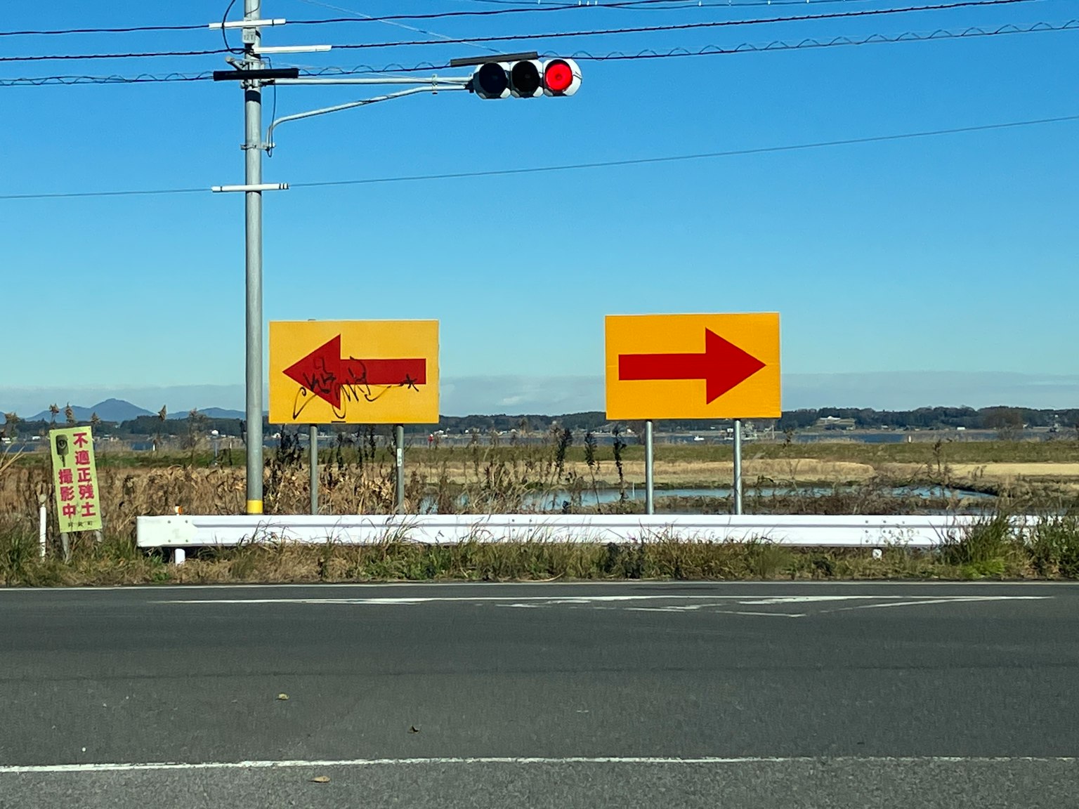 Señales de tráfico que indican direcciones a la izquierda y a la derecha con una luz roja