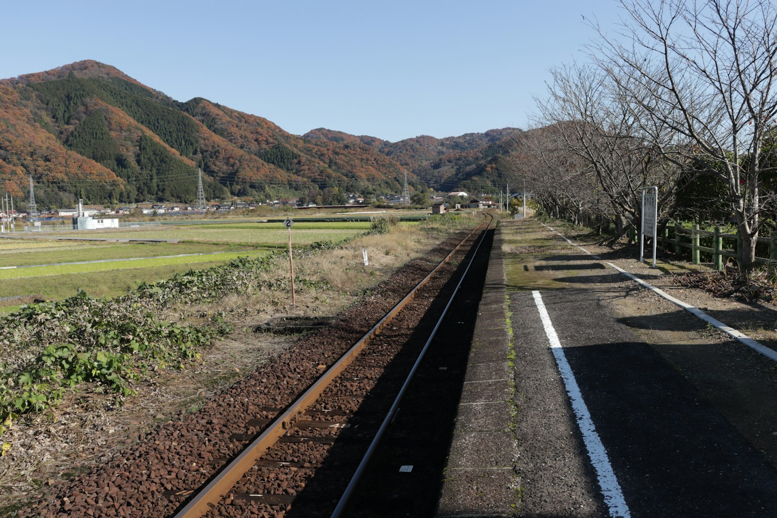 被稻田和山脈環繞的寧靜火車站平台