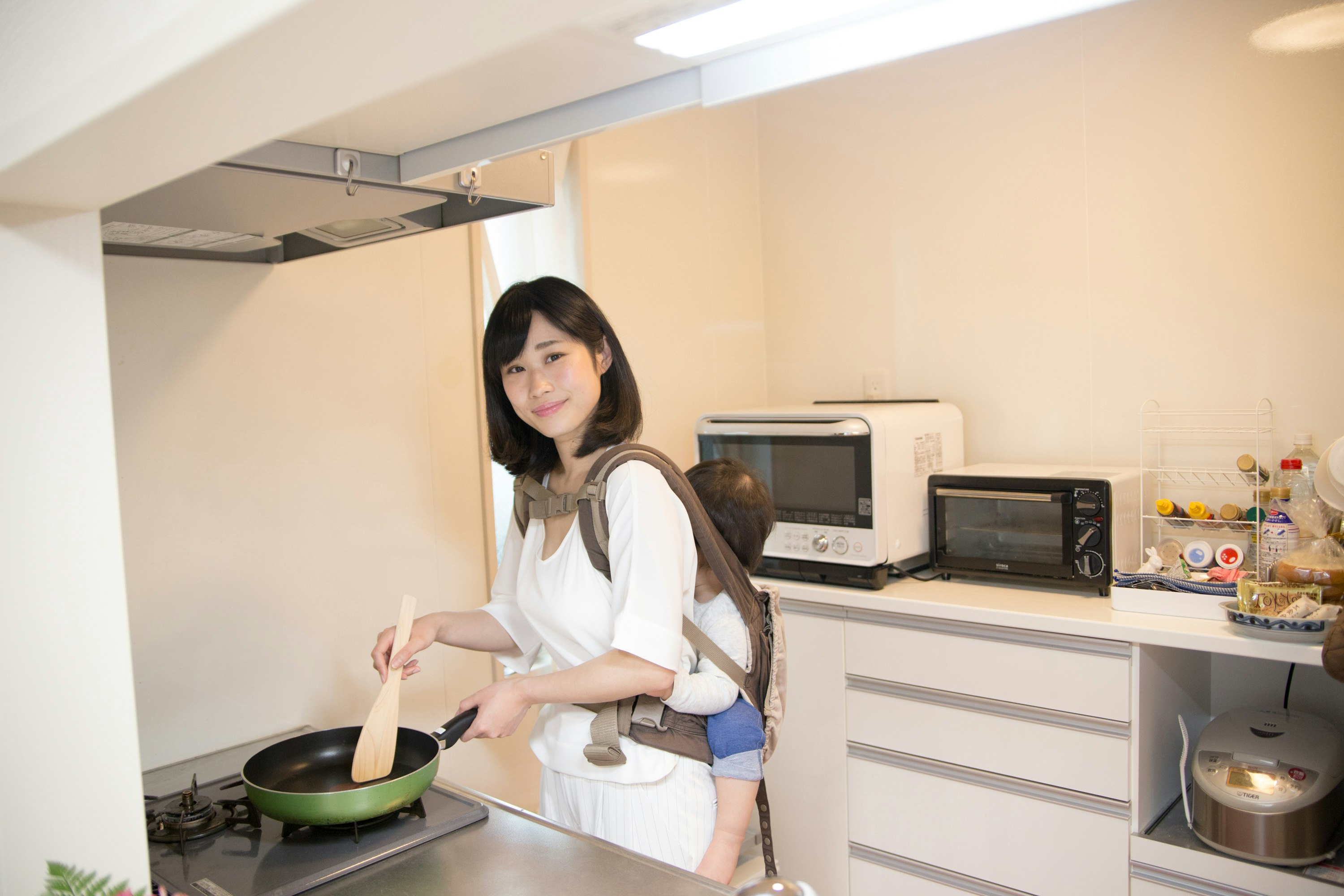 キッチンでフライパンを持つ女性