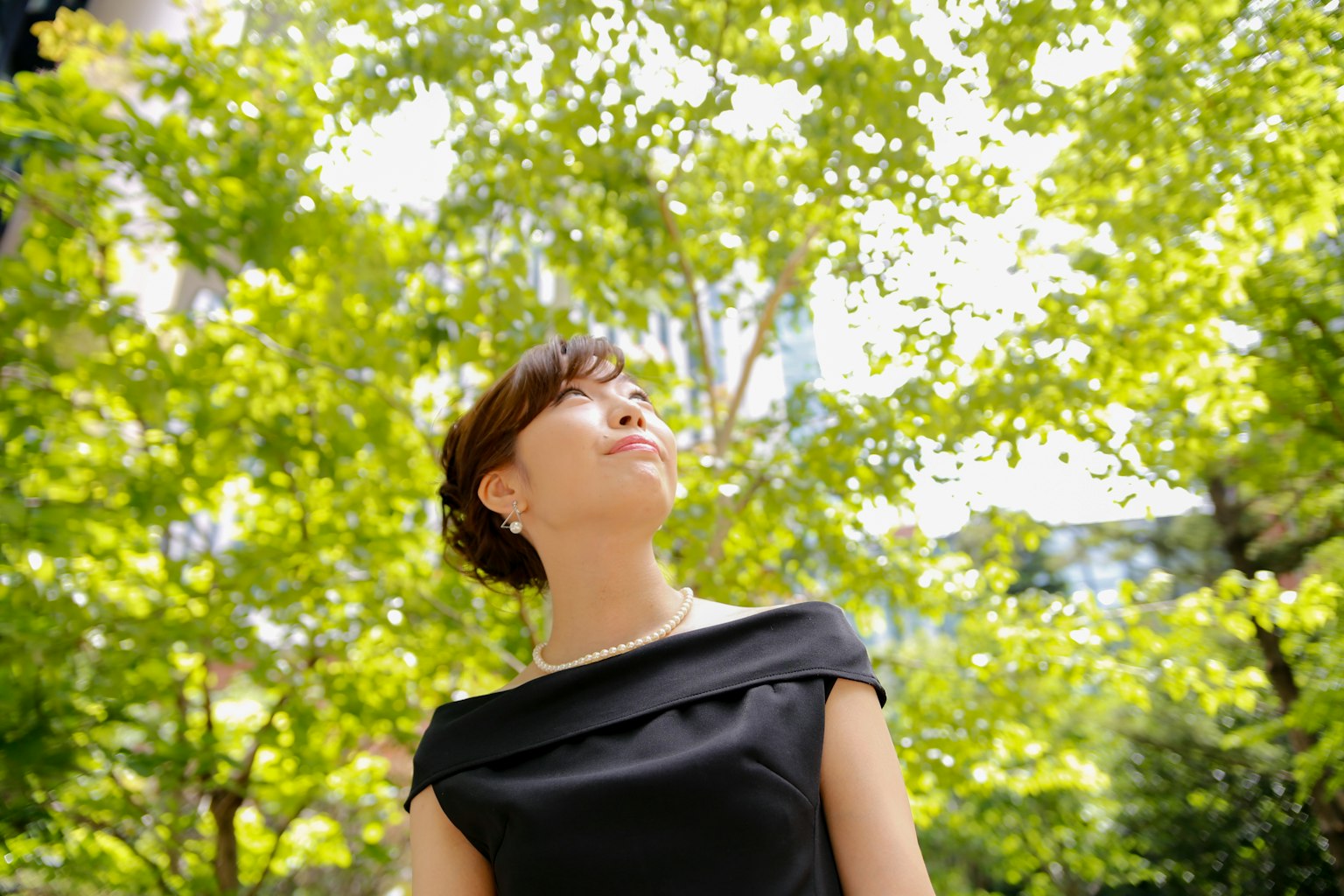 녹색 나무들 사이에서 미소 짓는 여성의 초상