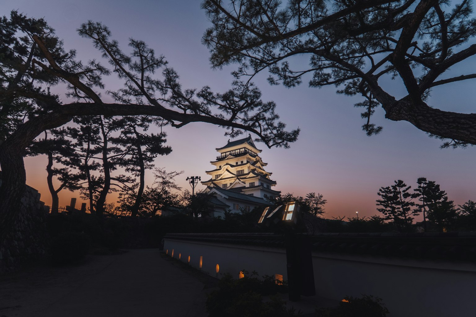 เงาของปราสาทที่สวยงามและต้นสนในยามพลบค่ำ