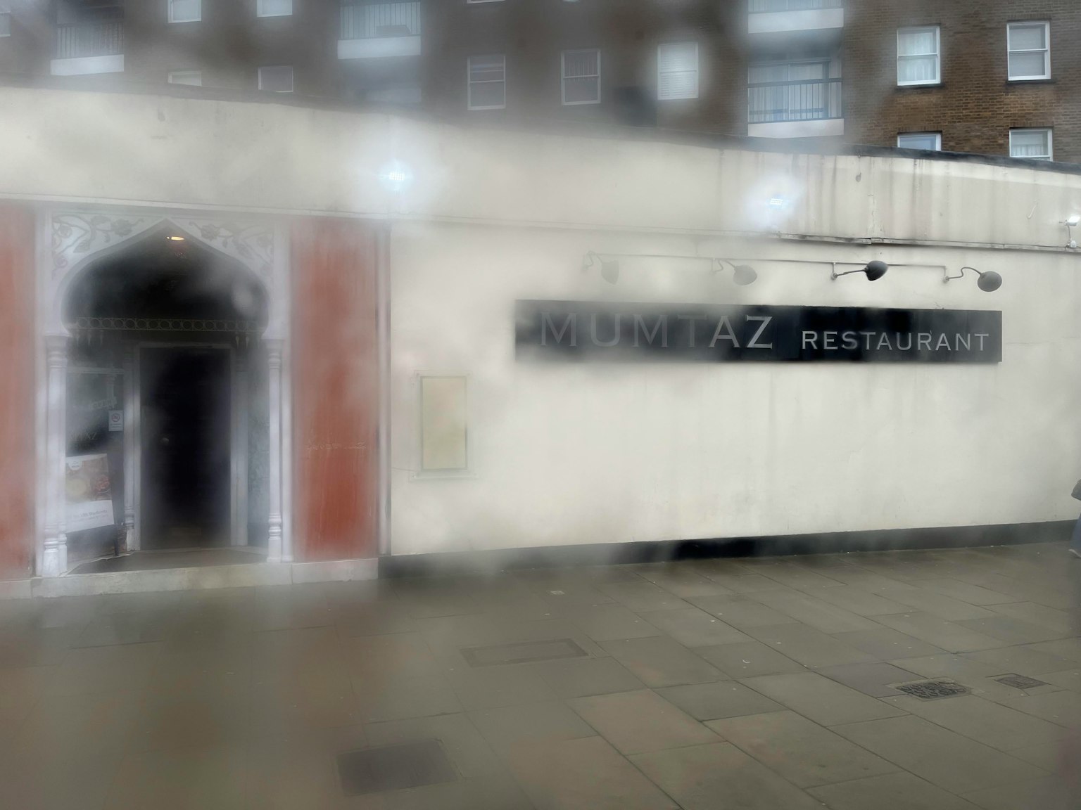 Verschwommene Bild eines Restaurant-Eingangs mit weißer Fassade