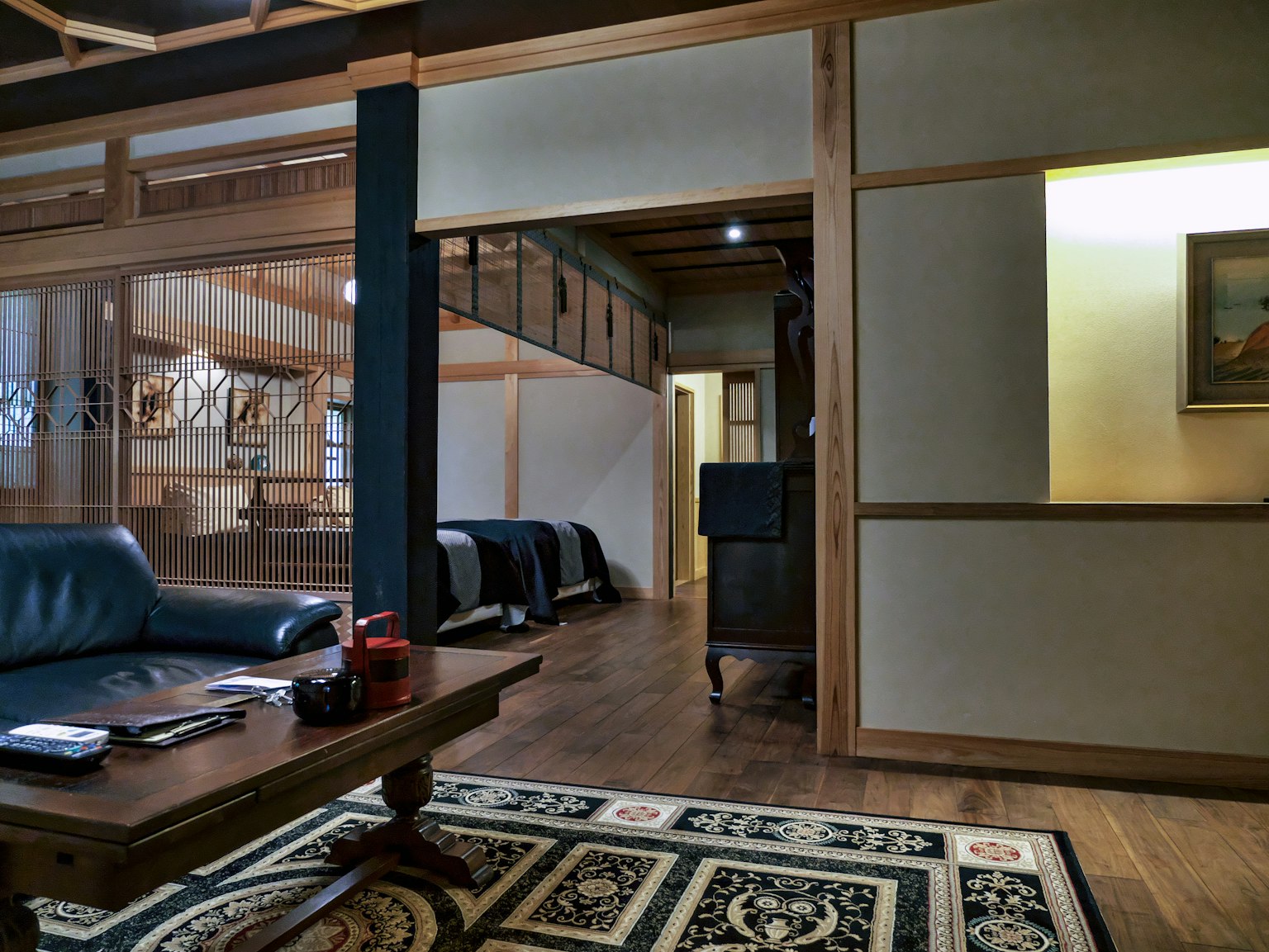 Ein Raum mit einem blauen Sofa und einem Holztisch im traditionellen japanischen Stil