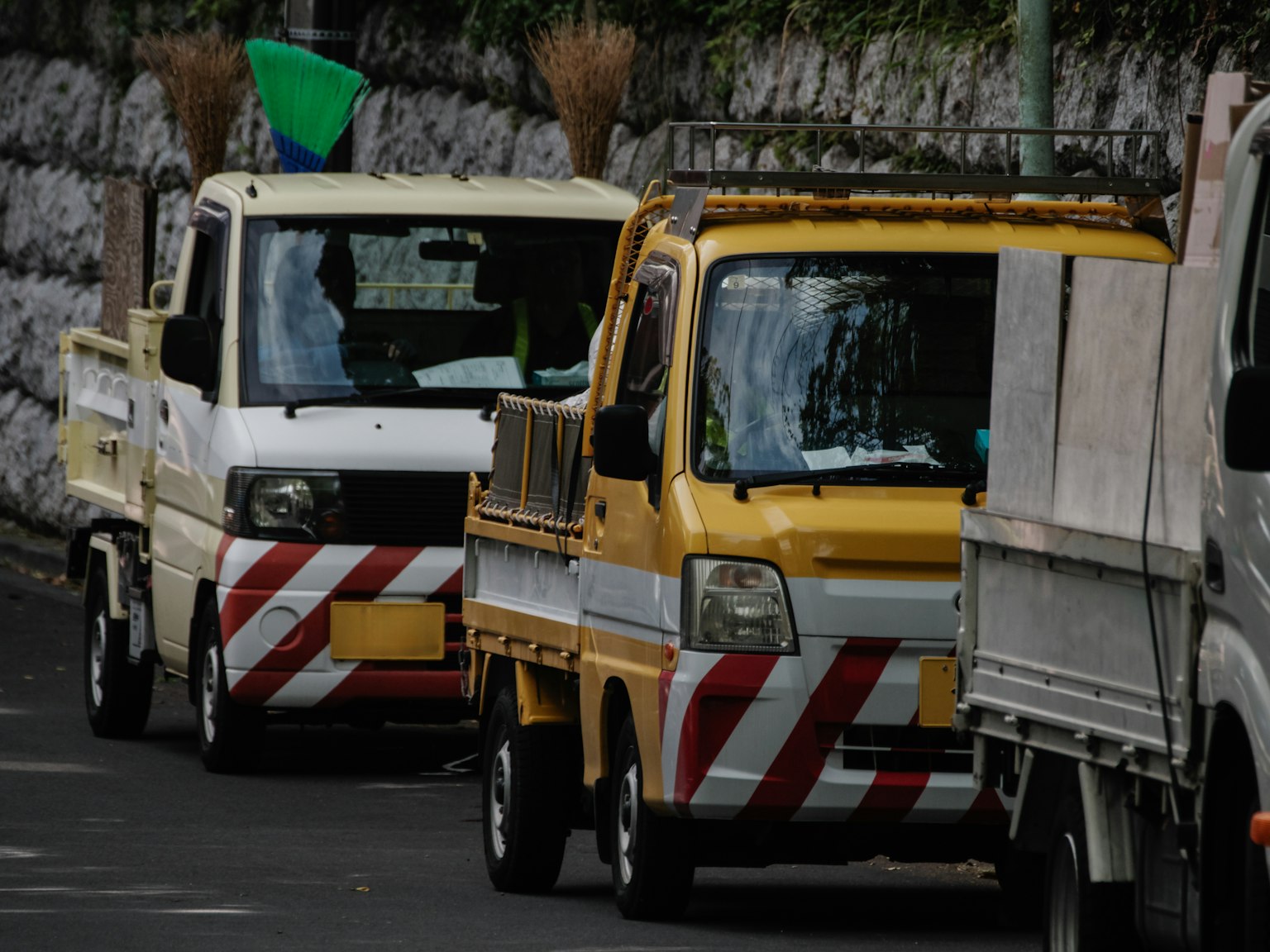Una fila di camion gialli e bianchi in una strada di città