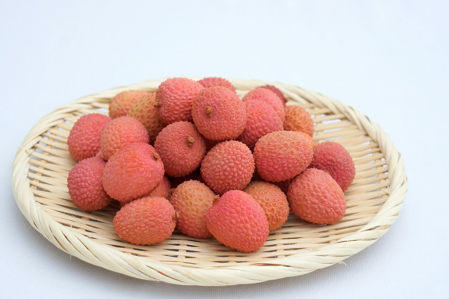 Frutti di lychee freschi disposti in un cesto intrecciato