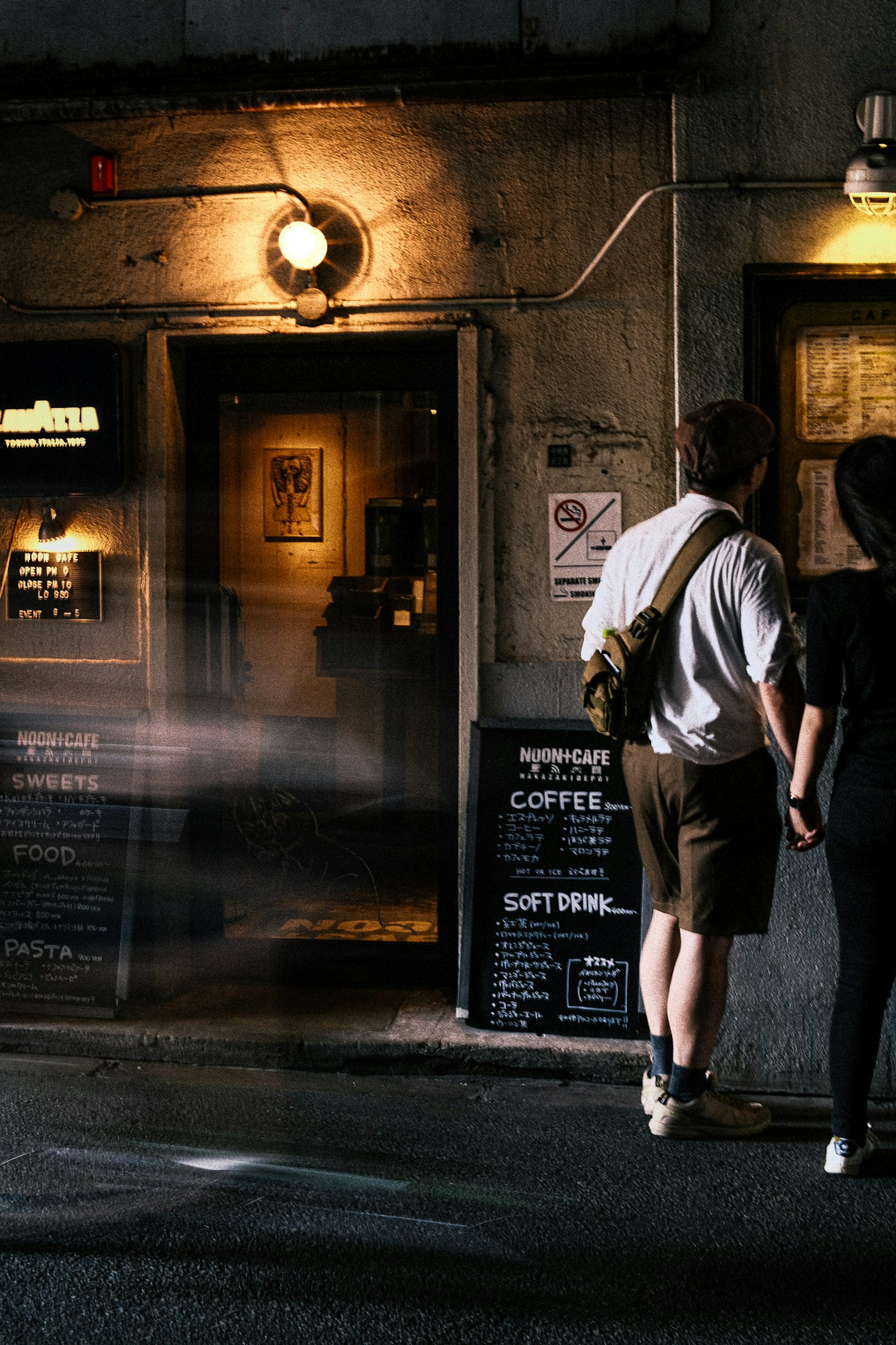 Silhouette d'un couple se tenant la main devant un café avec une entrée de bâtiment ancien en arrière-plan