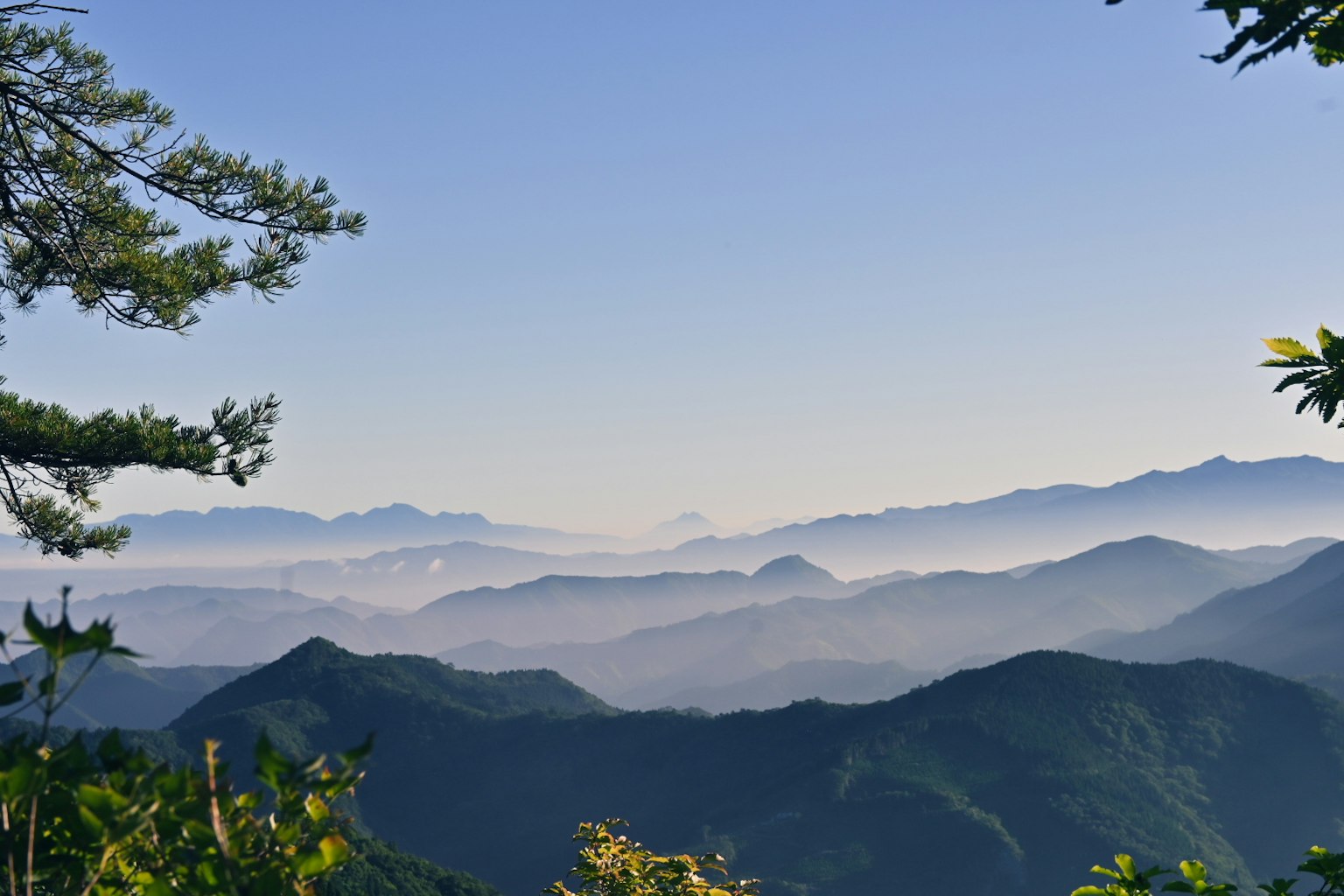 Impresionante vista de montañas superpuestas bajo un cielo azul