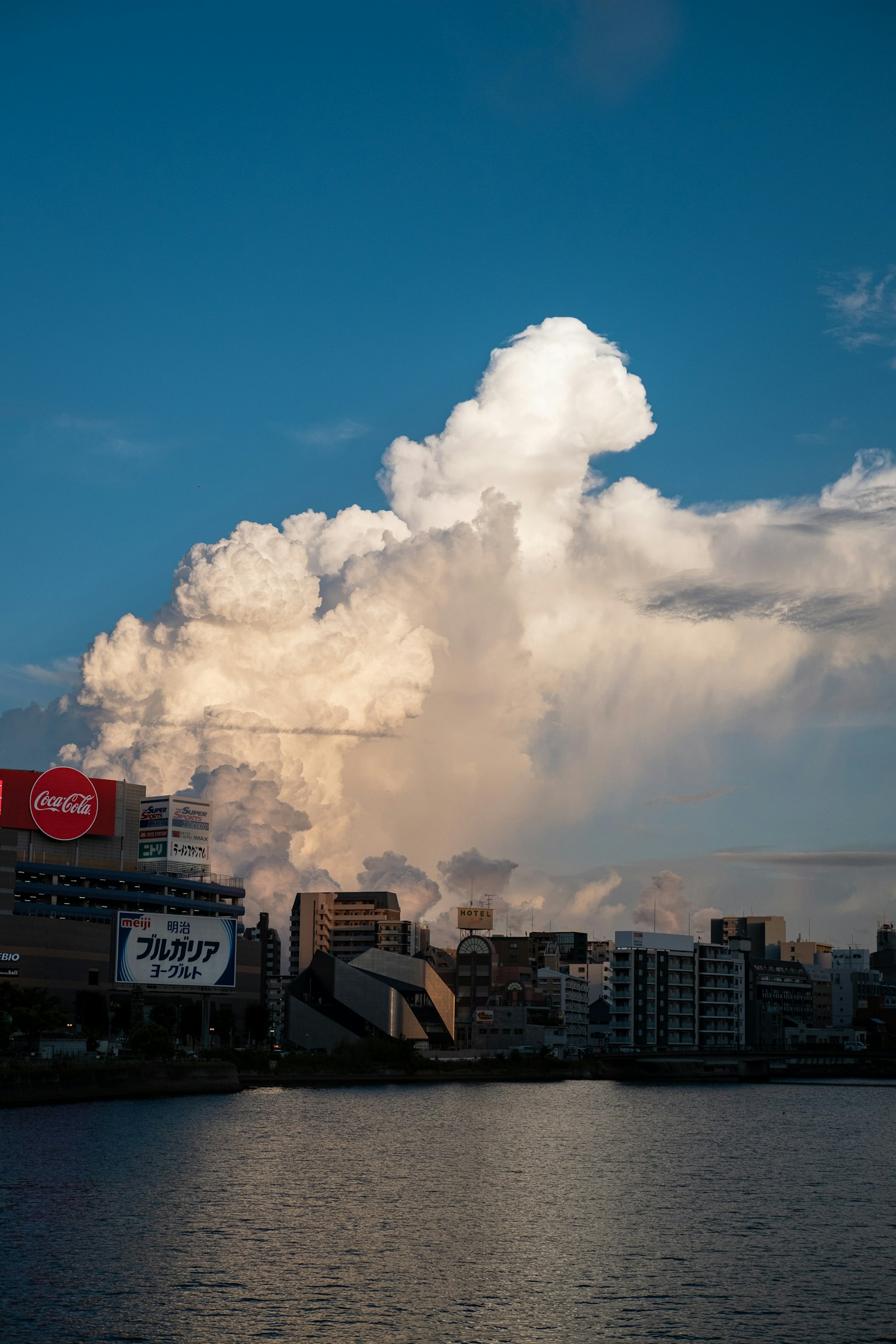Nube grande bajo el cielo azul con paisaje urbano