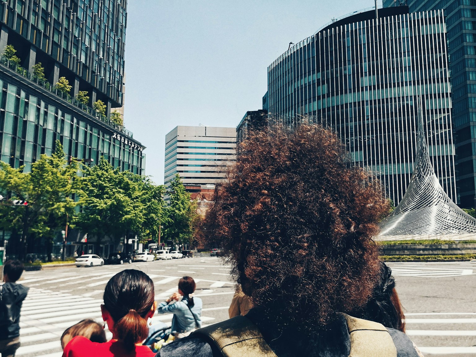 Personas esperando en una intersección de la ciudad Varios edificios de fondo