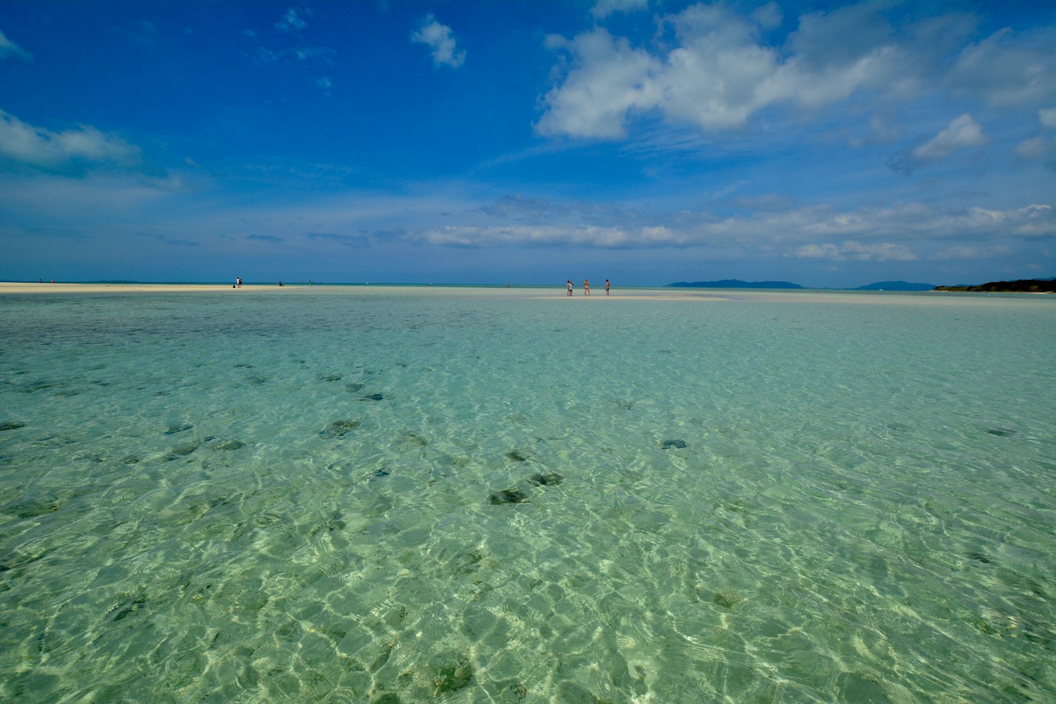Clear water beach scene with blue sky