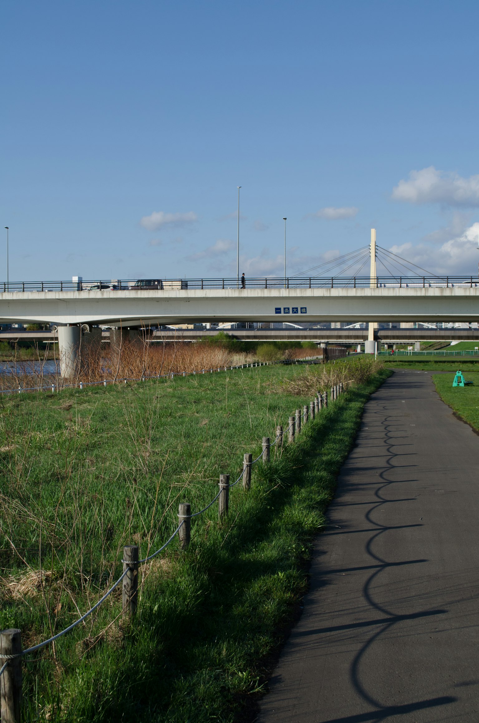 Vue pittoresque d'un chemin au bord de la rivière et d'un pont sous un ciel bleu
