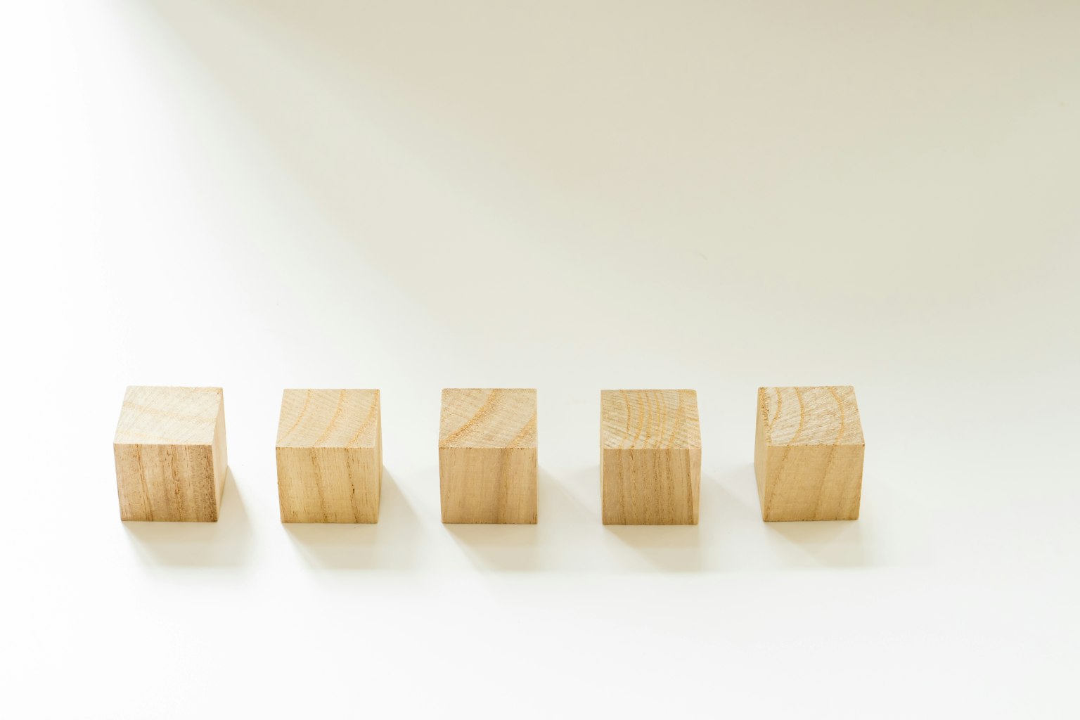 Cinco cubos de madera dispuestos sobre un fondo blanco