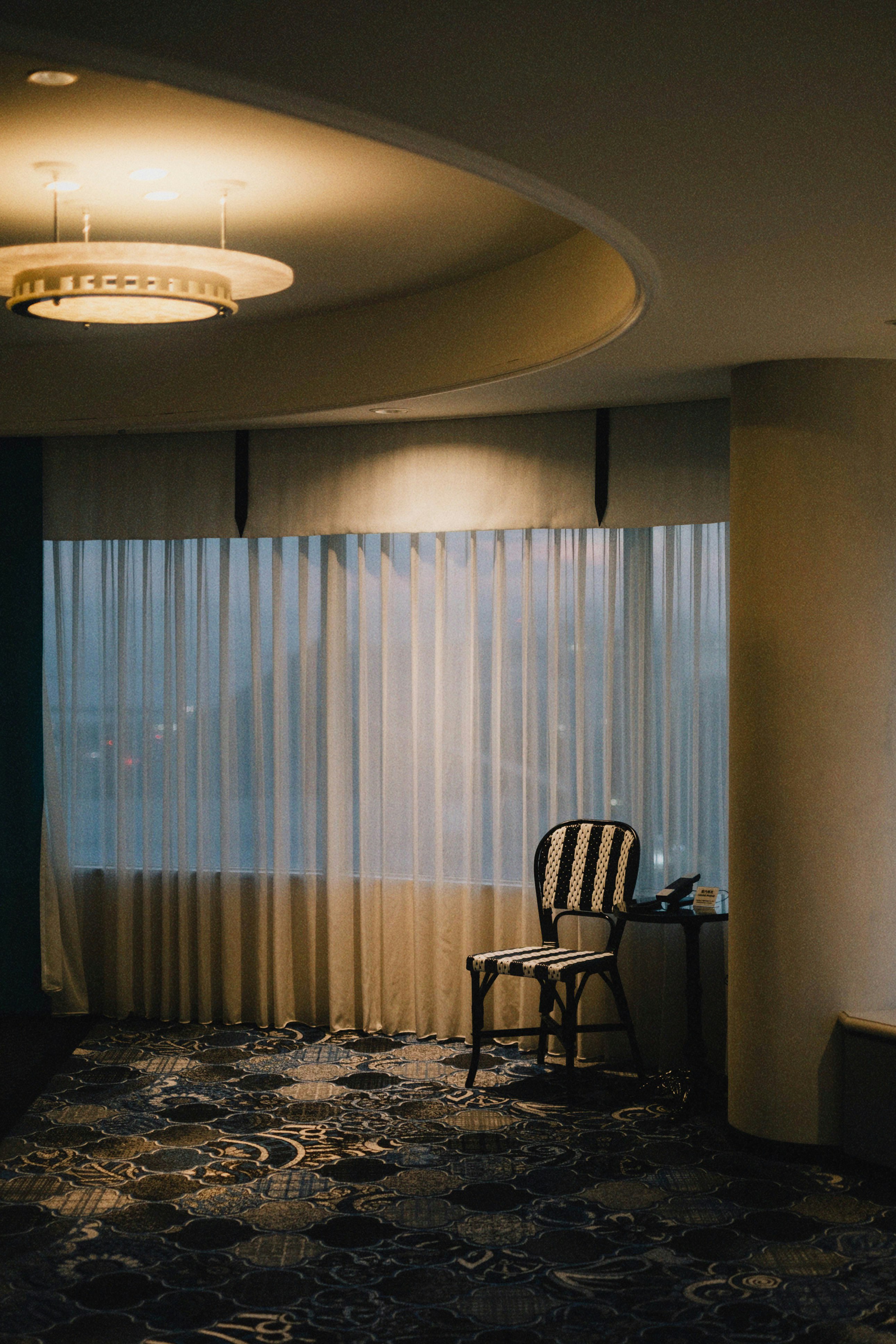 intérieur de chambre d’hôtel avec rideaux, lumière de fenêtre et fauteuil