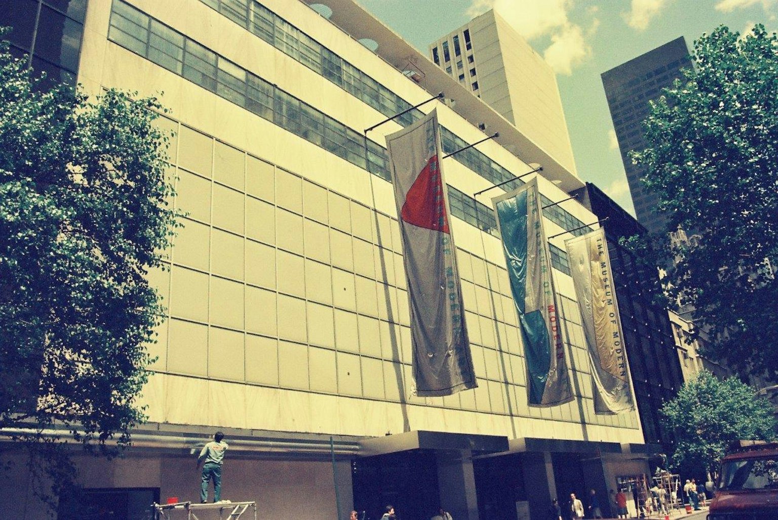 ด้านหน้าของอาคารสมัยใหม่ที่มีป้ายขนาดใหญ่แสดงอยู่