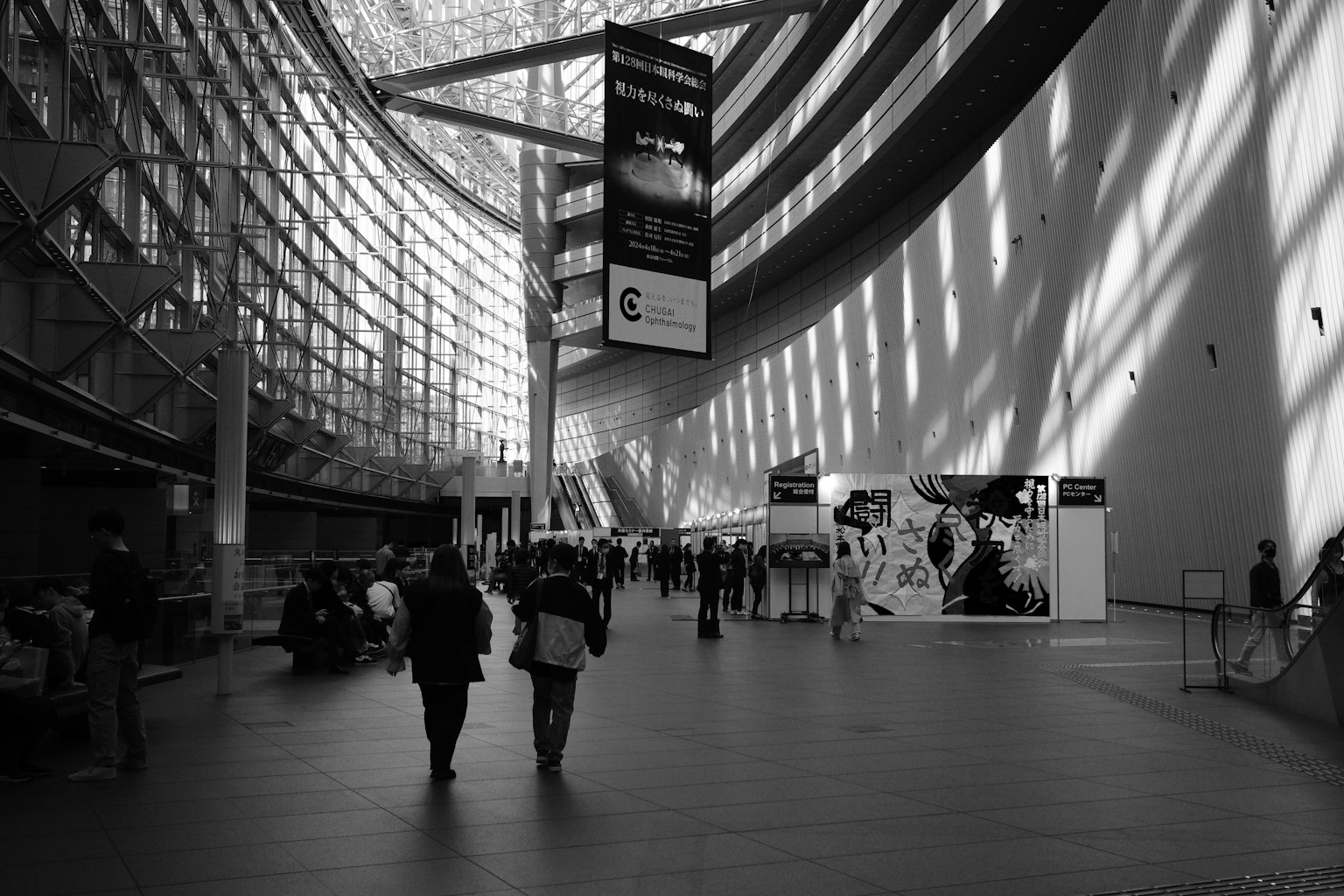 A black and white interior of modern architecture with people walking