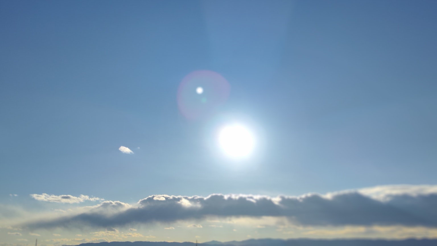 Sole luminoso in un cielo blu chiaro con nuvole