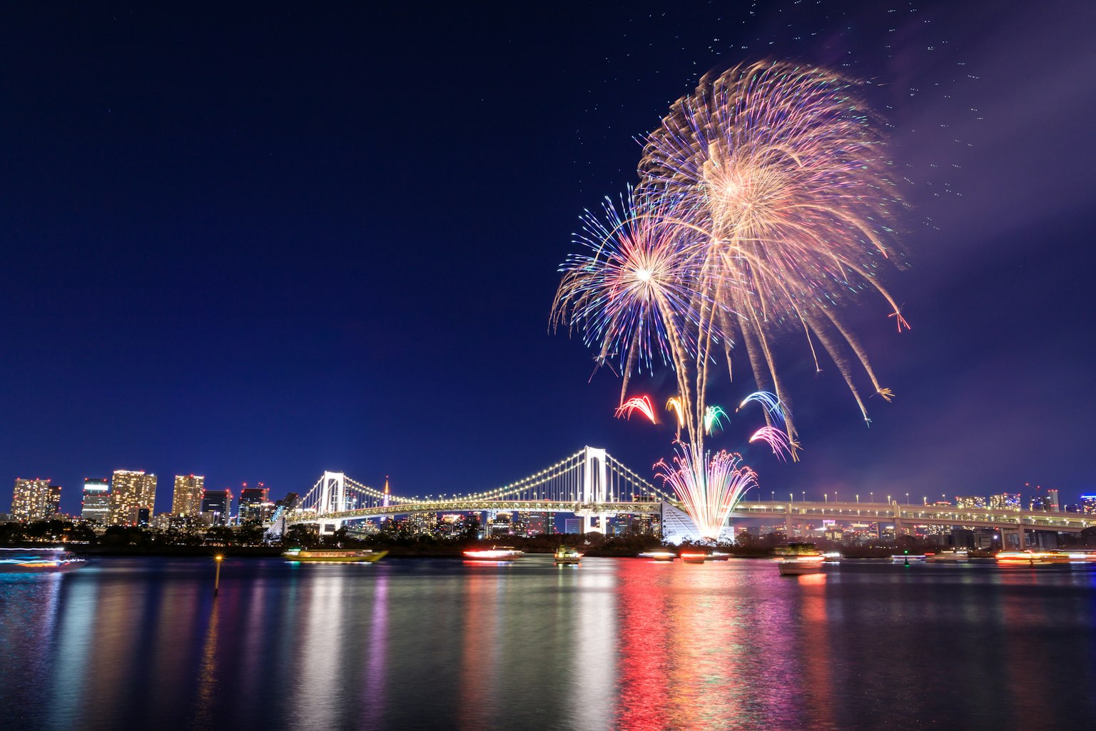 Feux d'artifice colorés au-dessus de la baie de Tokyo avec le pont Rainbow en arrière-plan