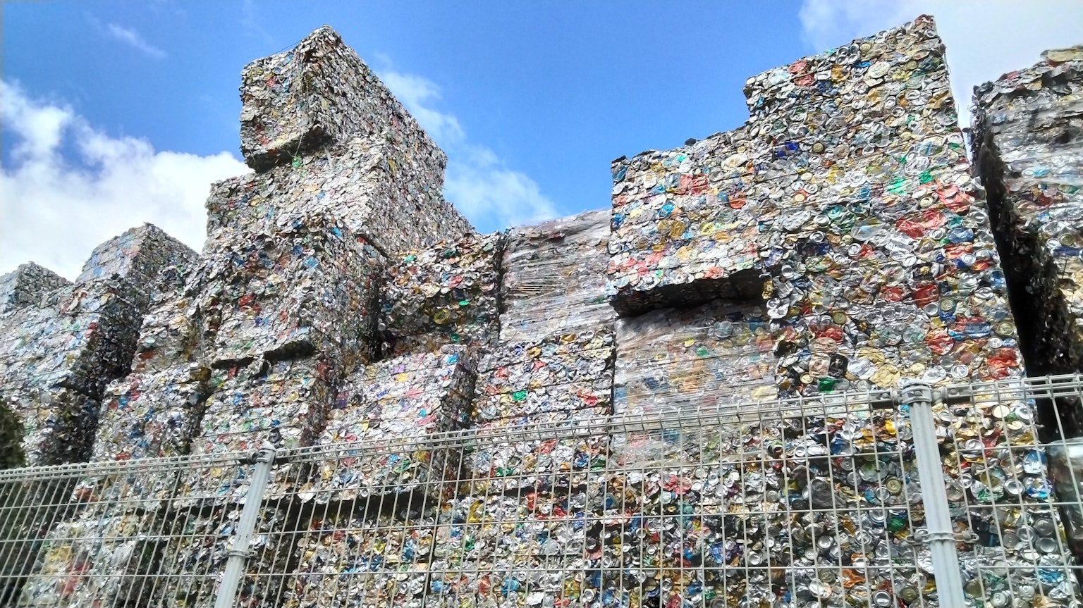 Pemandangan limbah plastik yang ditumpuk di bawah langit biru
