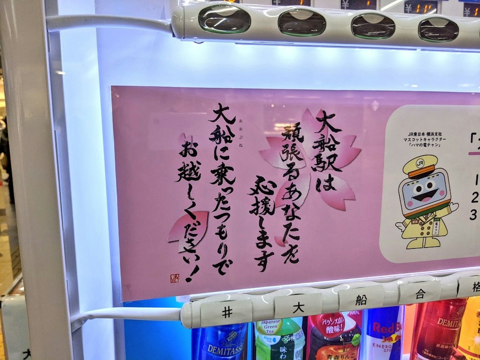 자판기 근처에 있는 분홍색 안내판 일본어로 된 메시지가 포함되어 있습니다