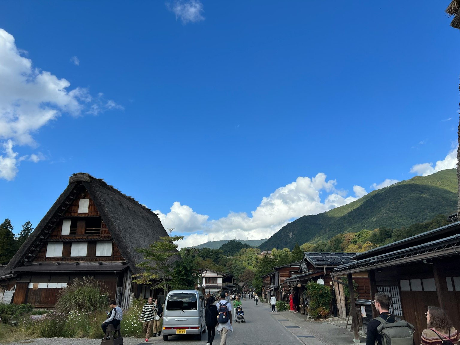 Scène de village japonais traditionnel avec des maisons à toit de chaume sous un ciel bleu