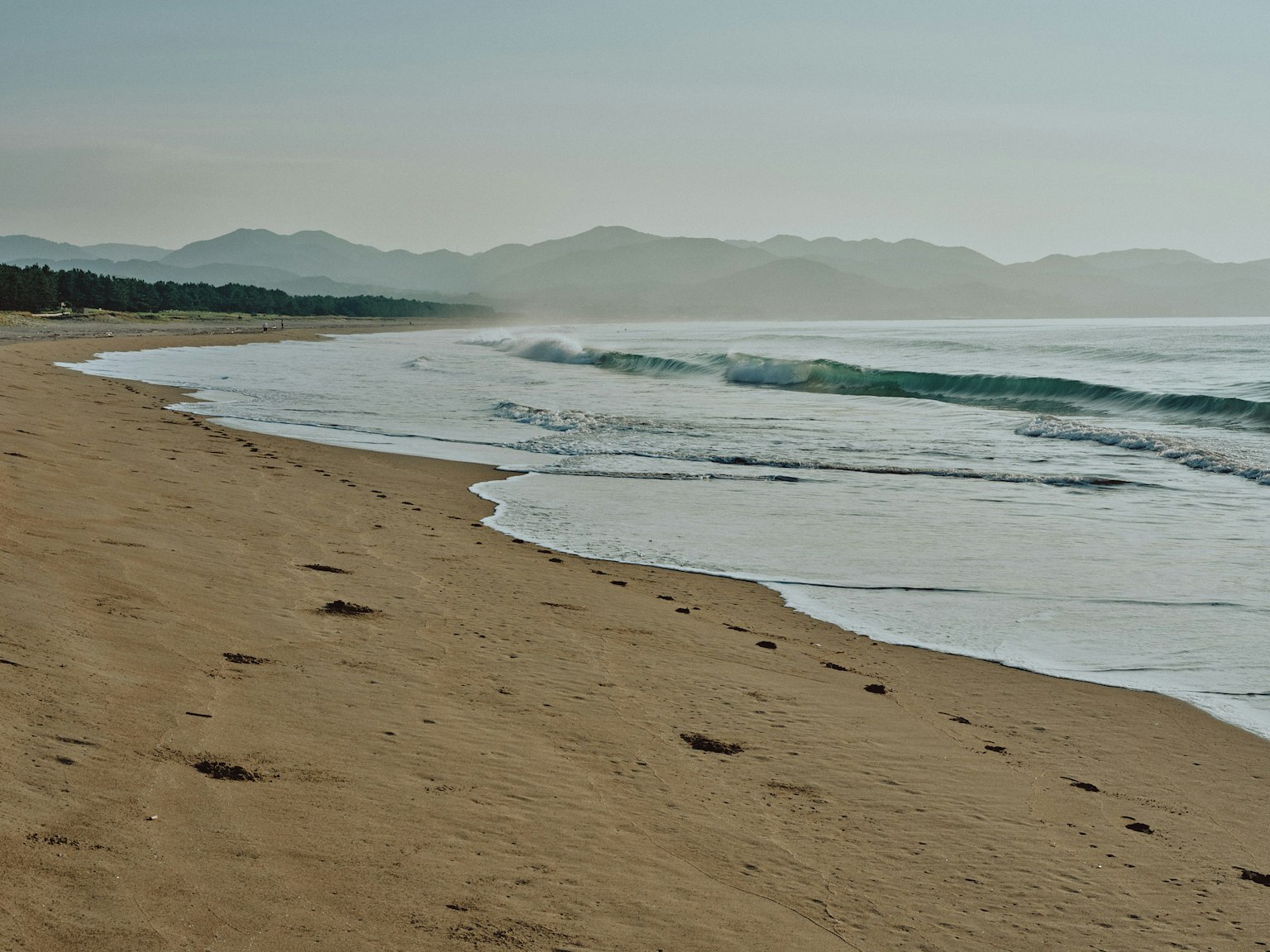 ทิวทัศน์ชายหาดที่เงียบสงบพร้อมคลื่นซัดเข้าหาชายหาด