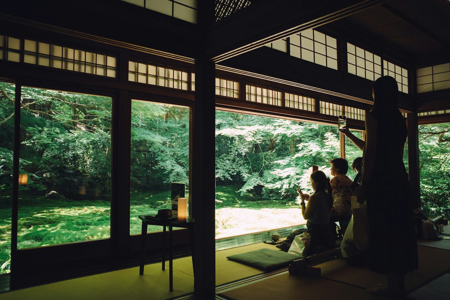 Vista de una serena sala de té japonesa que da a un jardín exuberante