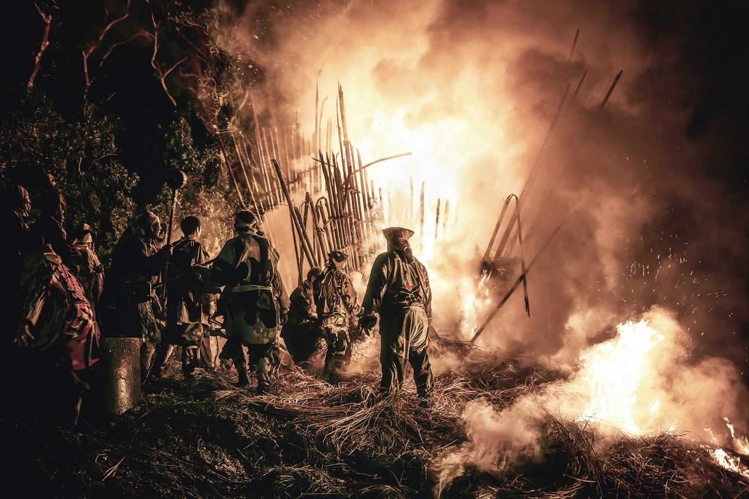 火の中で作業する人々と煙の中の炎