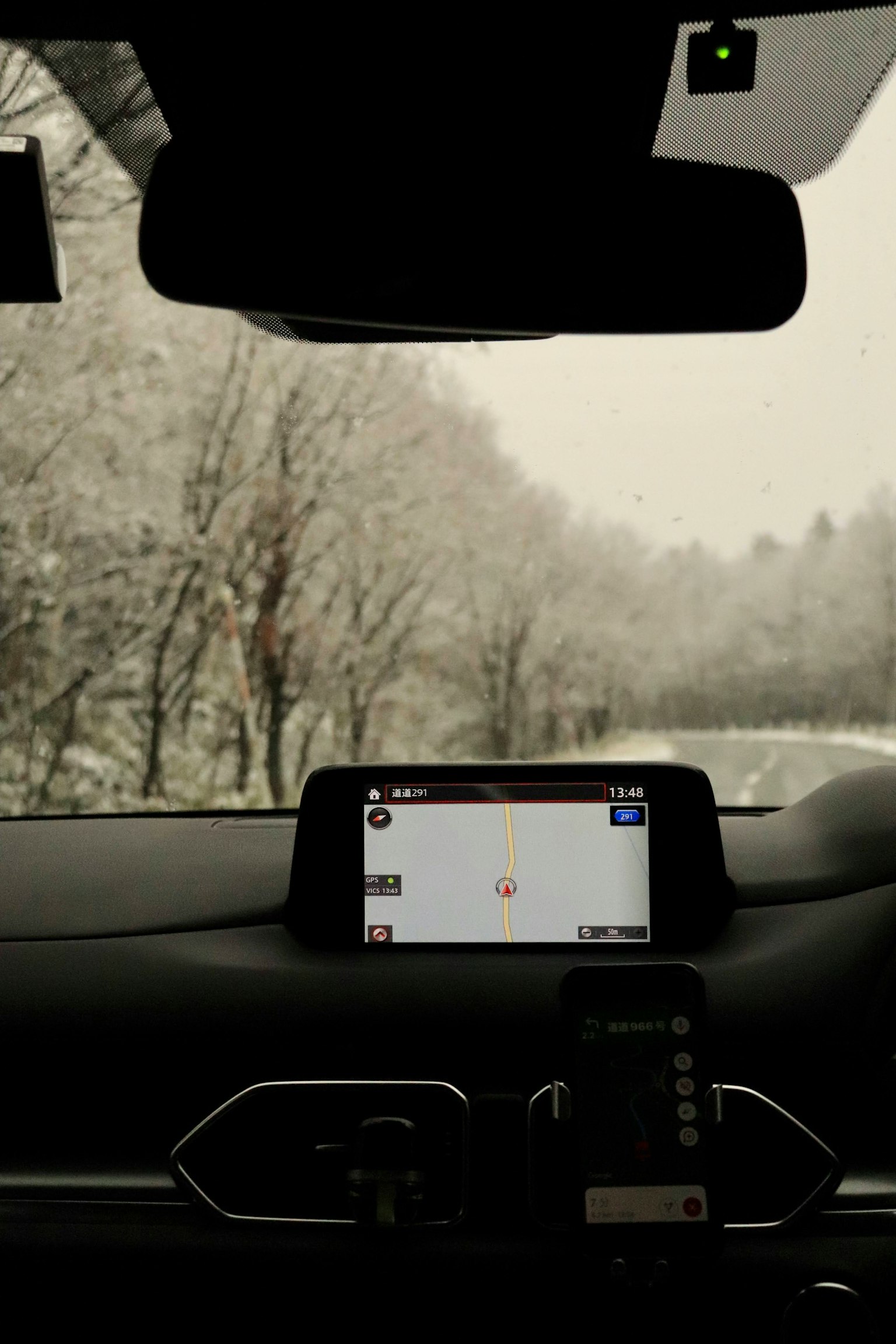Góc nhìn bên trong xe với màn hình GPS và cảnh tuyết bên ngoài