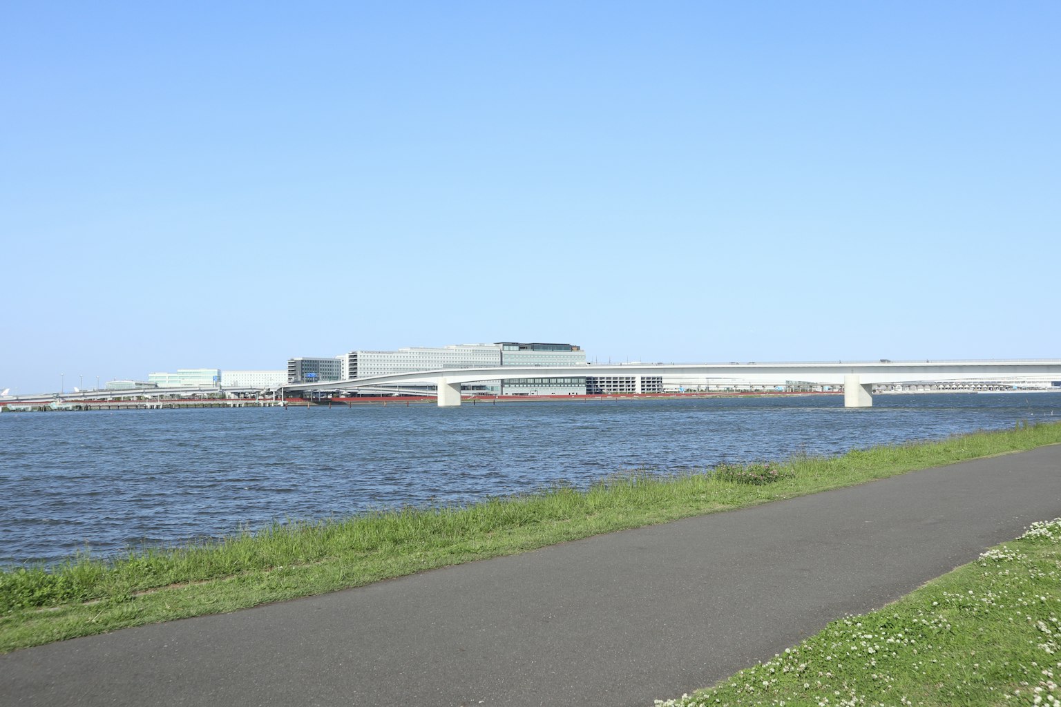 Vue pittoresque d'une rivière sous un ciel bleu avec un chemin pavé le long de la rive